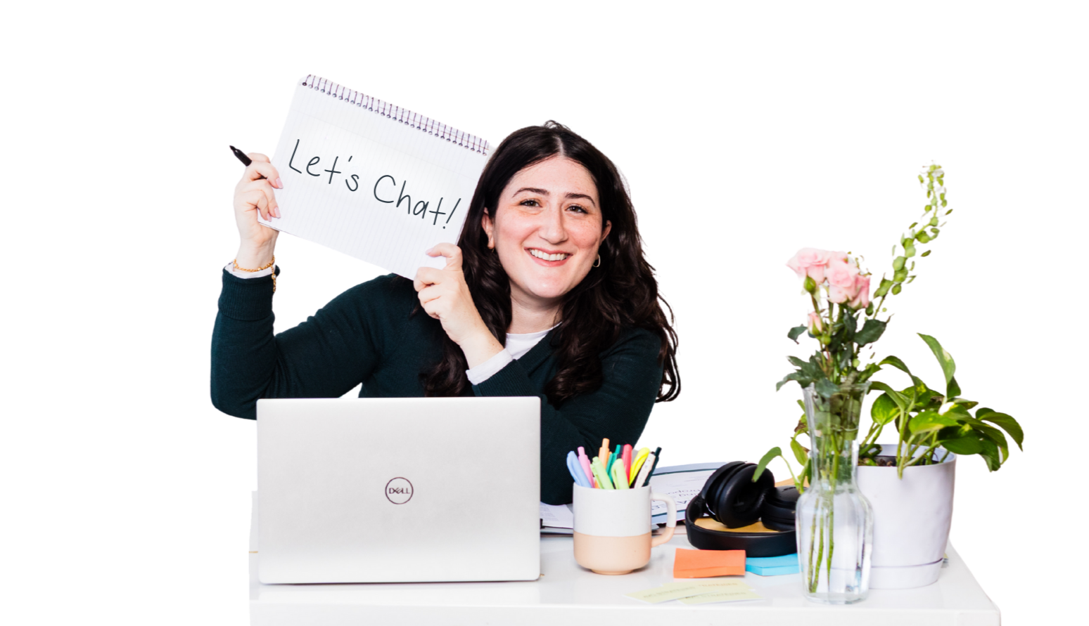 Aline sitting at desk while holding up a notebook that says Let's Chat