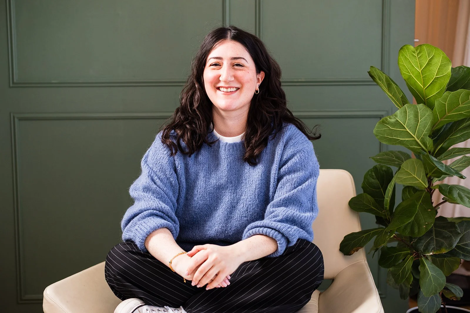 Aline sitting on a chair smiling