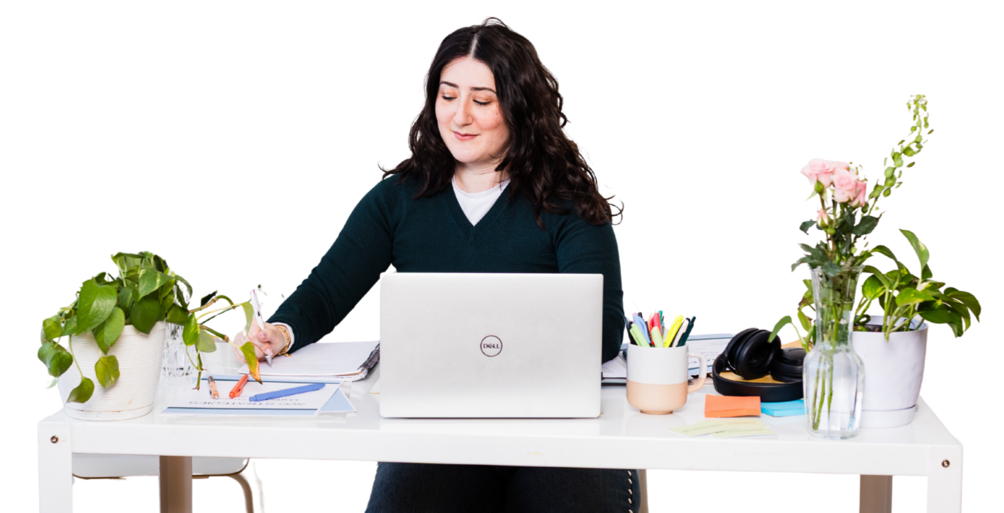 Aline working at her desk with a laptop and notebook