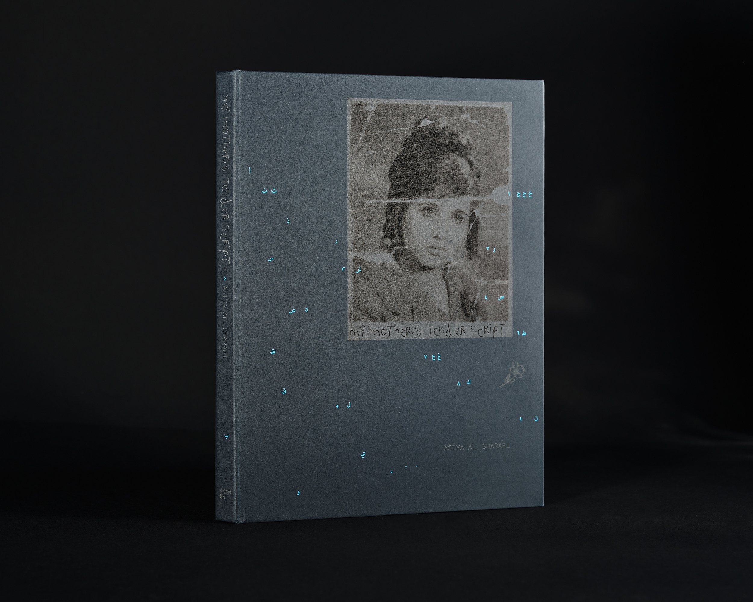 Book titled My Mother’s Tender Script by Asiya Al. Sharabi featuring an archival portrait of the artist’s mother surrounded by scattered Arabic letters and handwritten marks against a deep dark background.