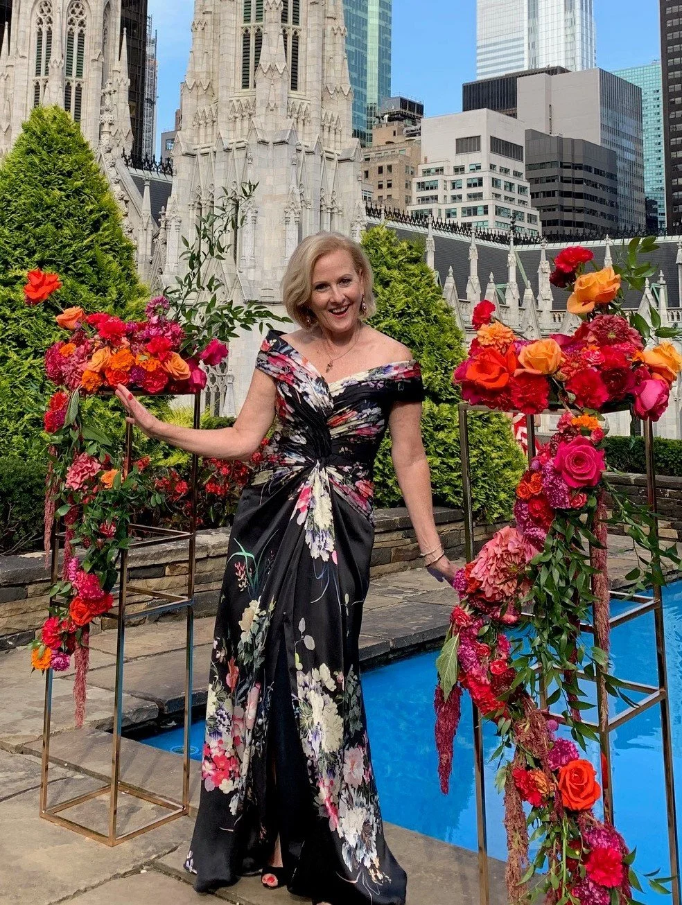 Wearing classic hand draping and looking so elegant on a New York rooftop in her custom Louise Alvarez couture mother of the bride evening gown. Cut in multi coloured silk satin and featuring a hand draped collar which formed sleeves.