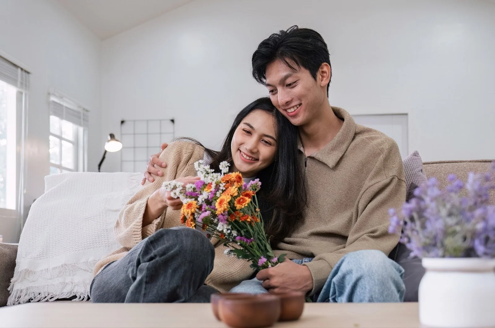 A smiling couple enjoying a romantic moment with fresh flowers