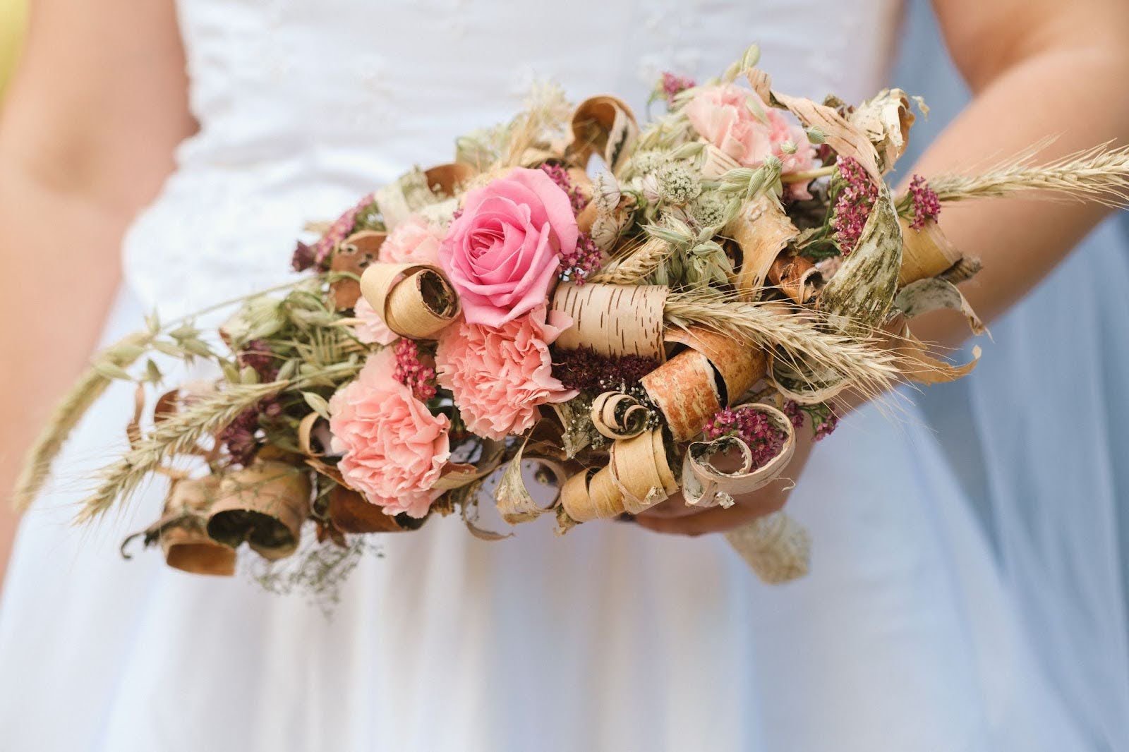 Close-up of a bride holding a unique, horizontal wedding bouquet