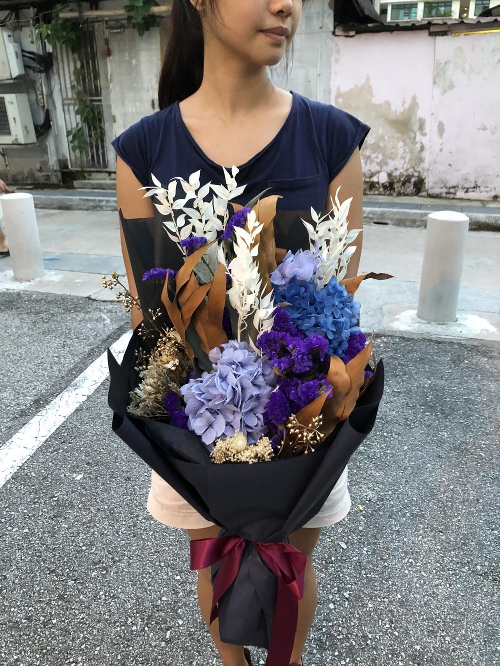 lady holding royally preserved flower bonquet