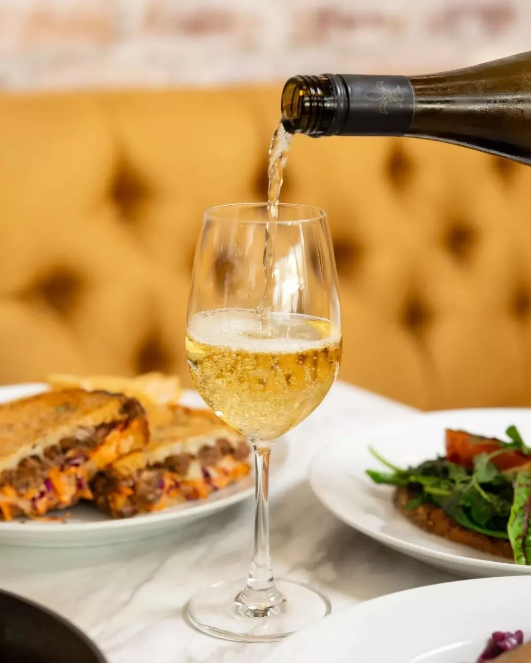 At Smoque, it starts with the pour, wine flowing, glasses clinking, and the table set for something special.

Then come the dishes, new flavours, bold plates, and food designed to be shared and savoured.

A dining experience that moves from first sip