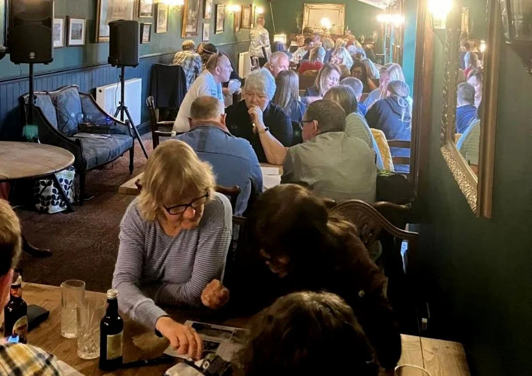 Restaurant full of people at tables chatting to one another