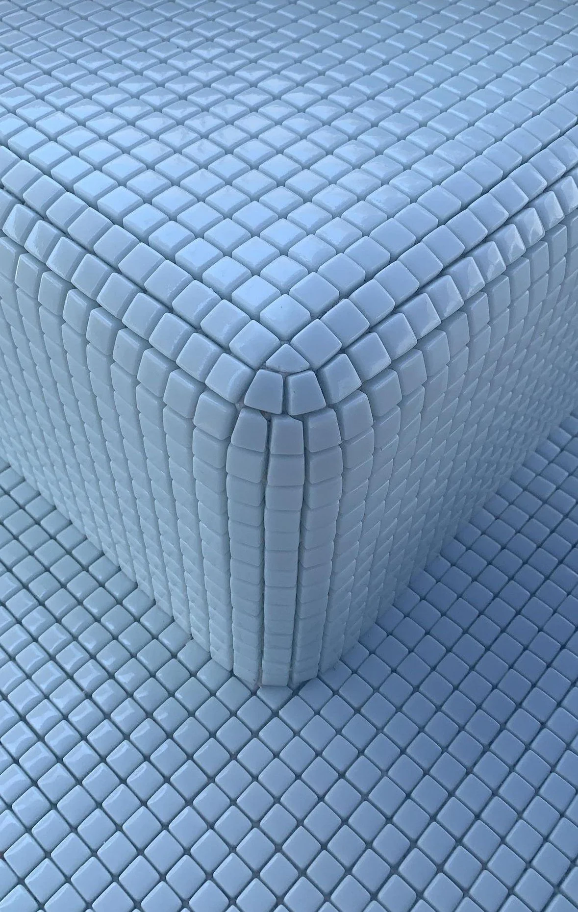 A room furniture piece made entirely of small, white, square tiles, including the structure and the floor.