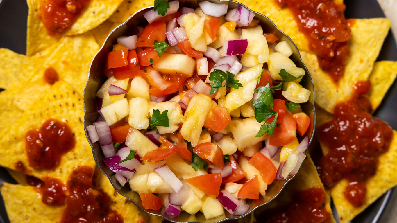 Bird’s-eye view of homemade pineapple salsa made with Simplyfruit pineapple, served with tortilla chips.