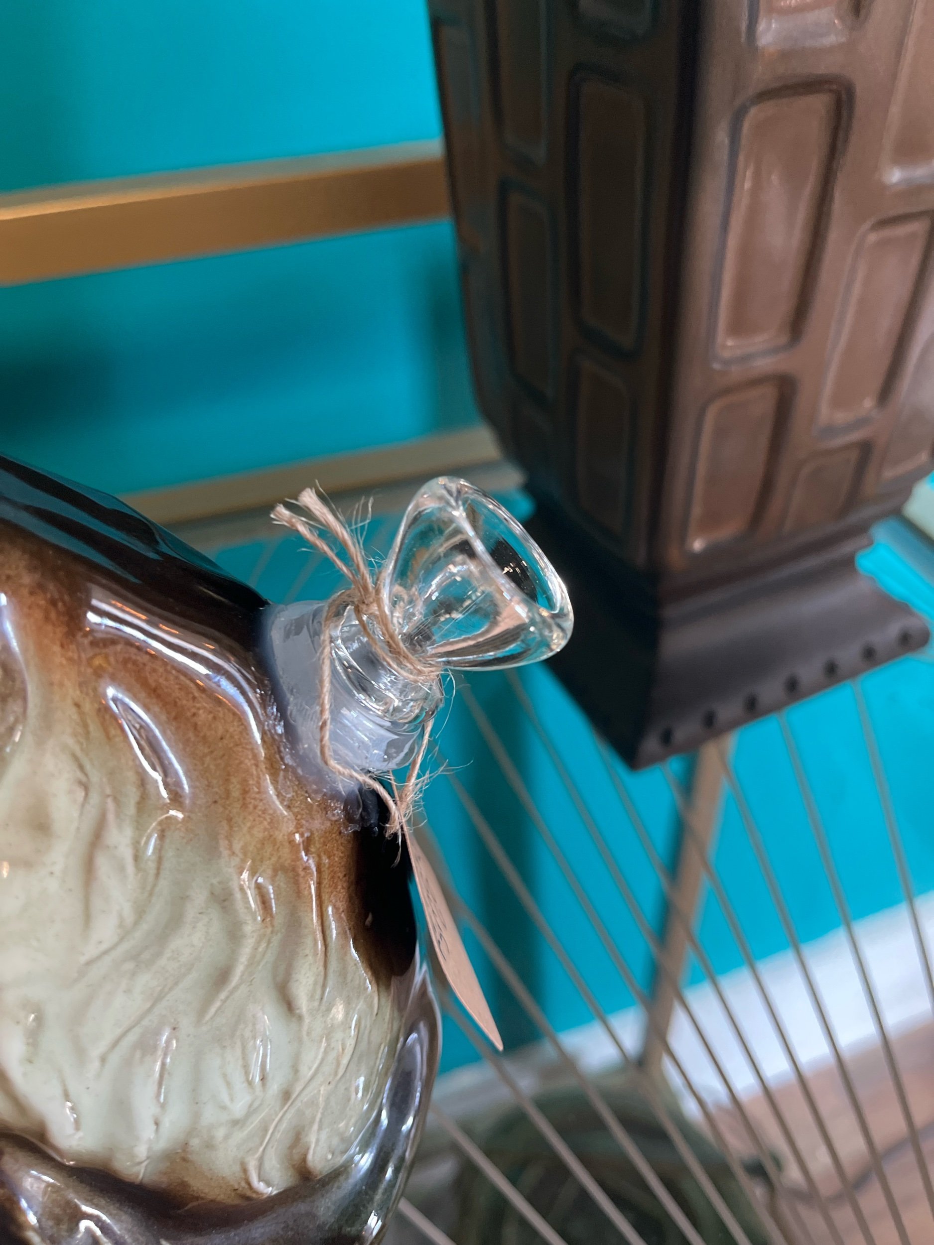 An image of a magnificent vintage decanter shaped as a cat, displaying the bowl that is on it.