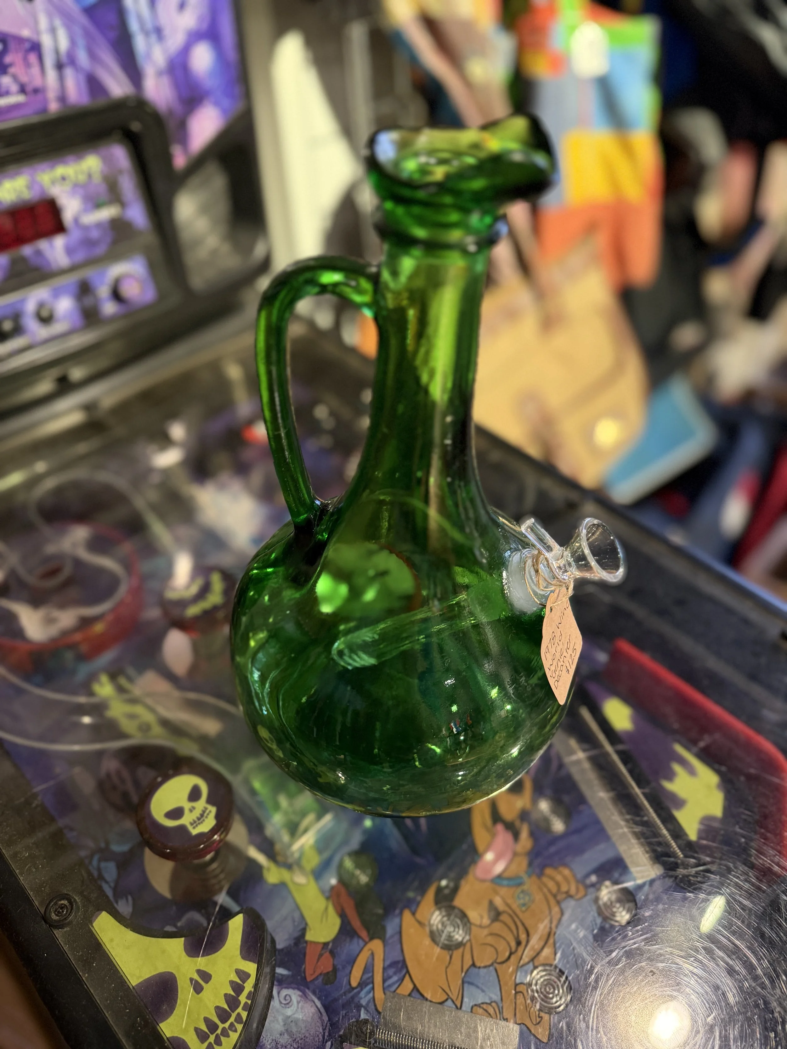 Image of a vintage green decanter that is a 1978 Wine World "Genie" Decanter that has been changed into a bong from Retro Smoke Co. from the top angle with the bowl visible.