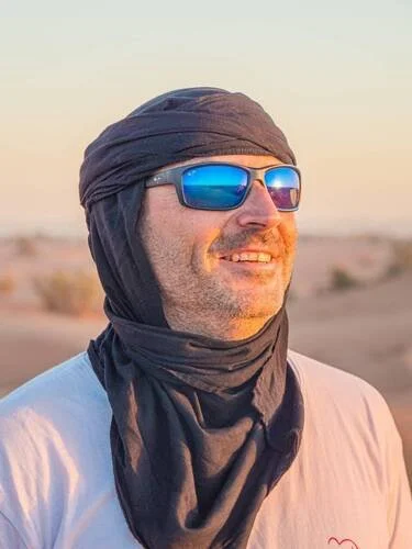 Homme souriant, en train de faire une marche dans le désert marocain