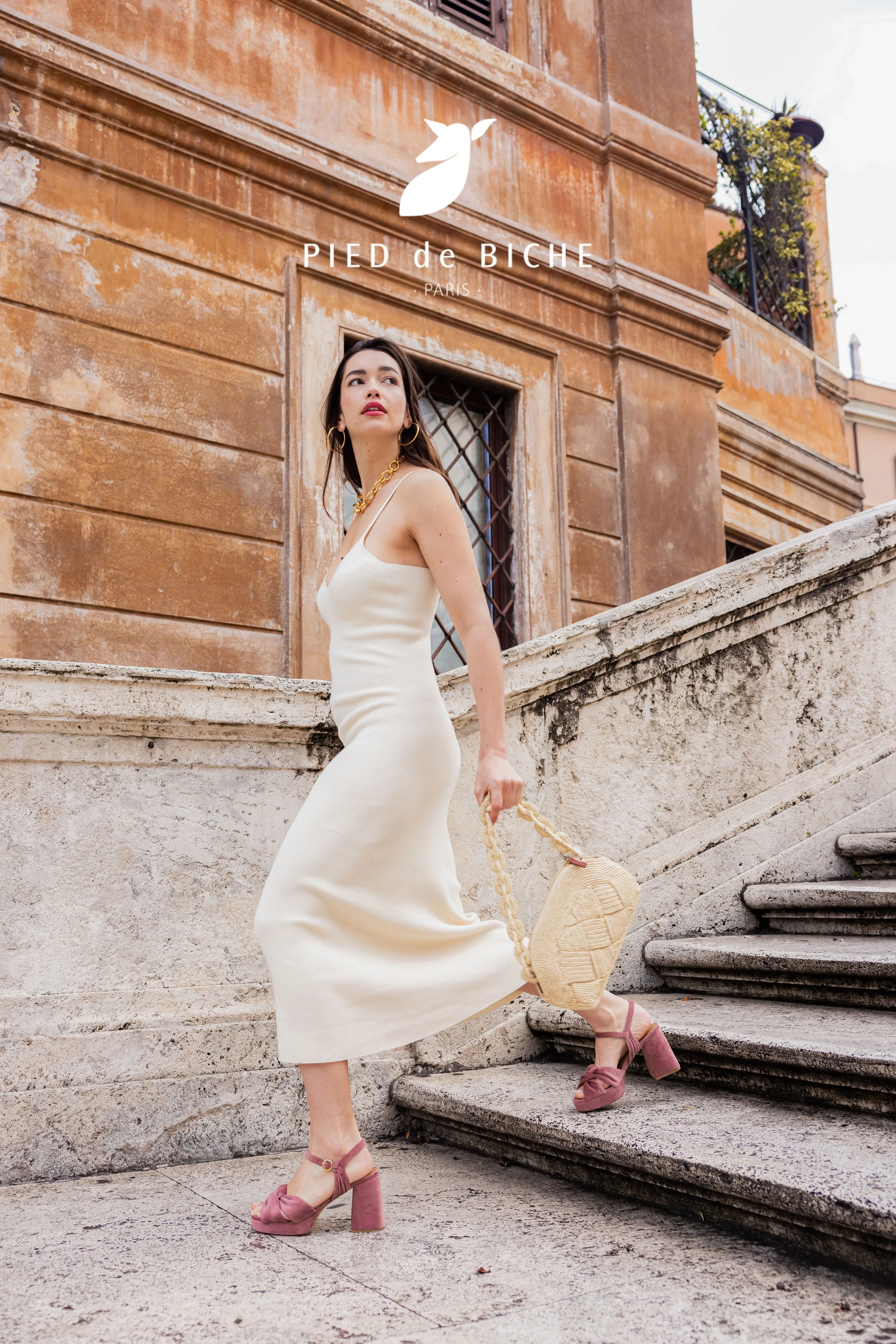 Mannequin portant une robe claire et descendant des escaliers en pierre