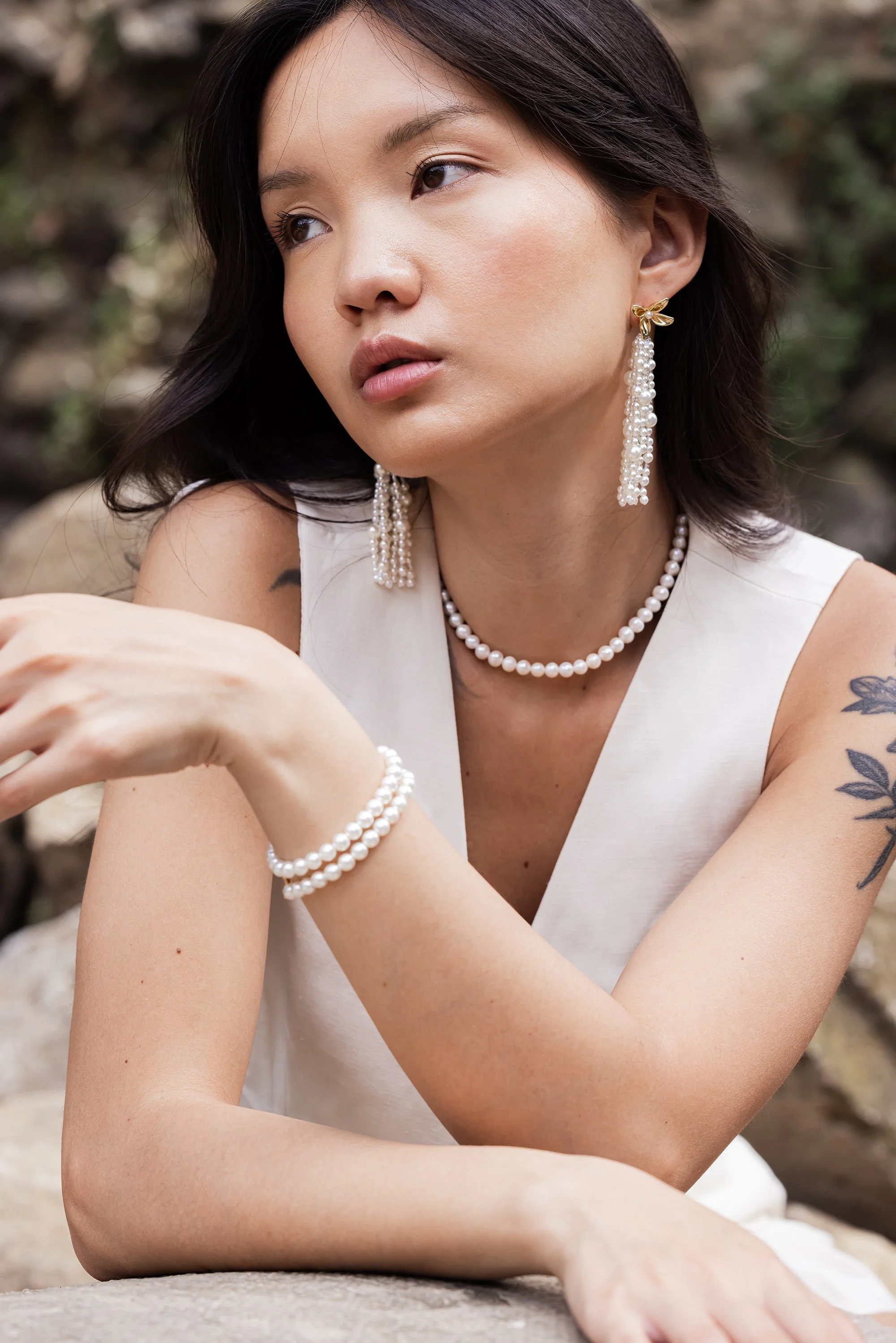 Portrait d'une mannequin en extérieur portant une parure de bijoux de mariage en perles