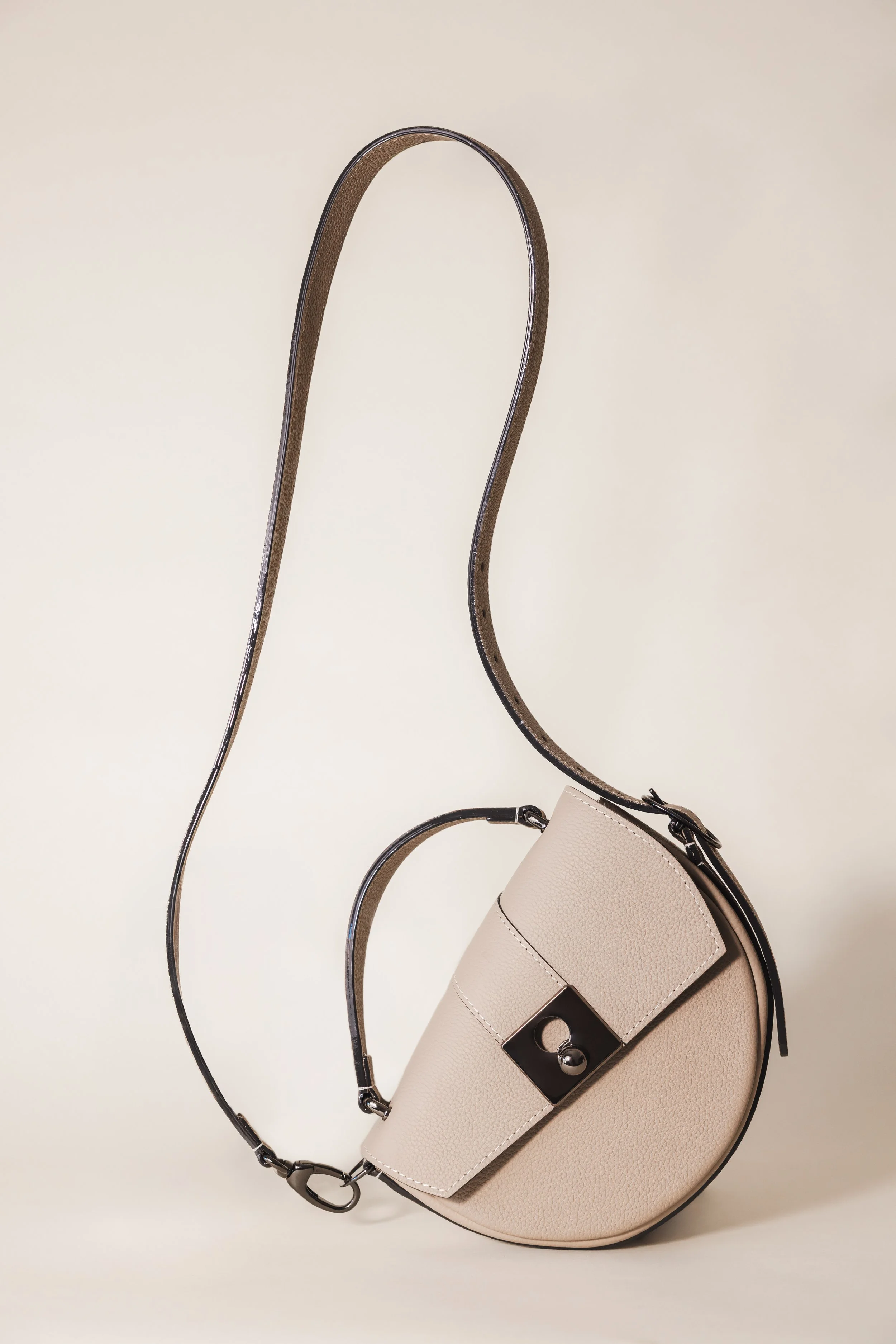 Sac arrondi beige dans un studio sur fond neutre