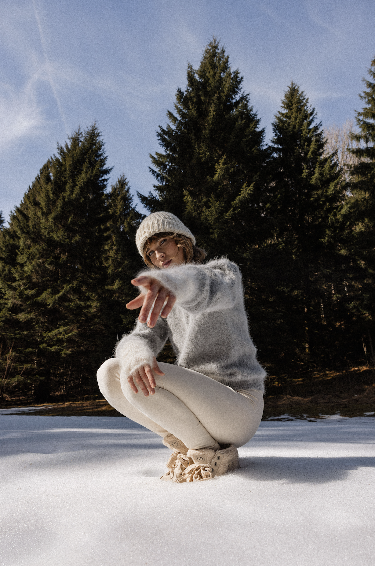 Femme posant assise dans la neige illustrant le traitement d'une photo après retouches