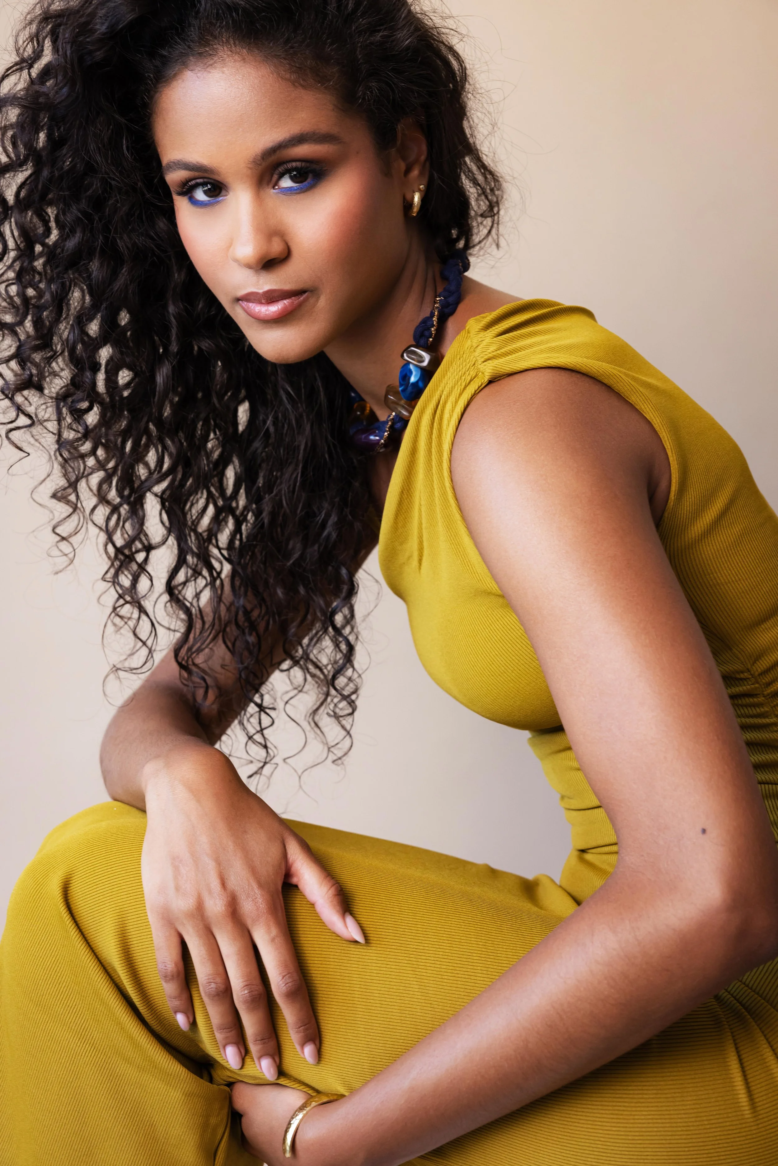 Portrait d'une mannequin en studio sur un fond neutre et portant une robe jaune 