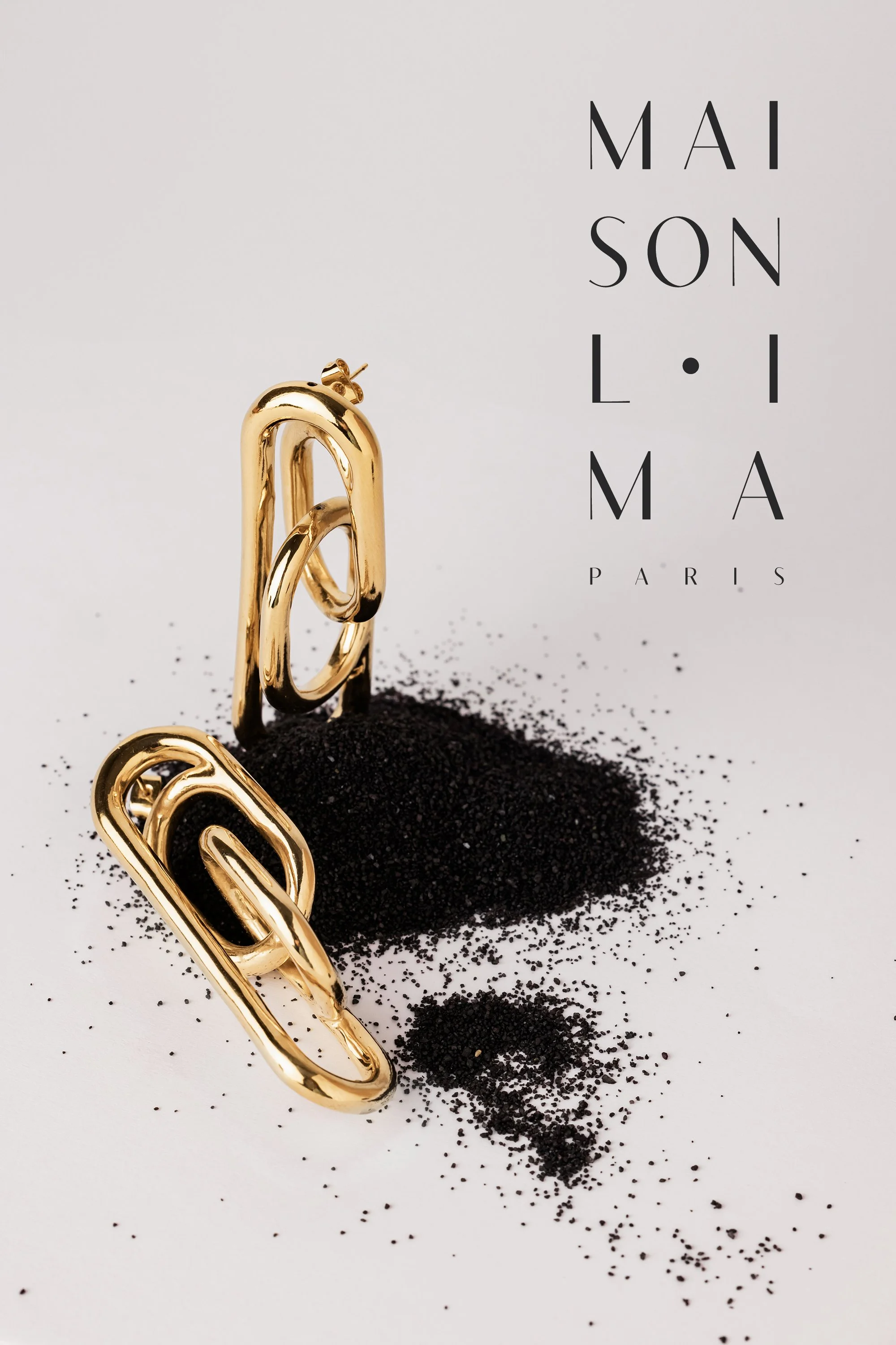 Boucles d'oreilles photographiées en studio sur du sable noir