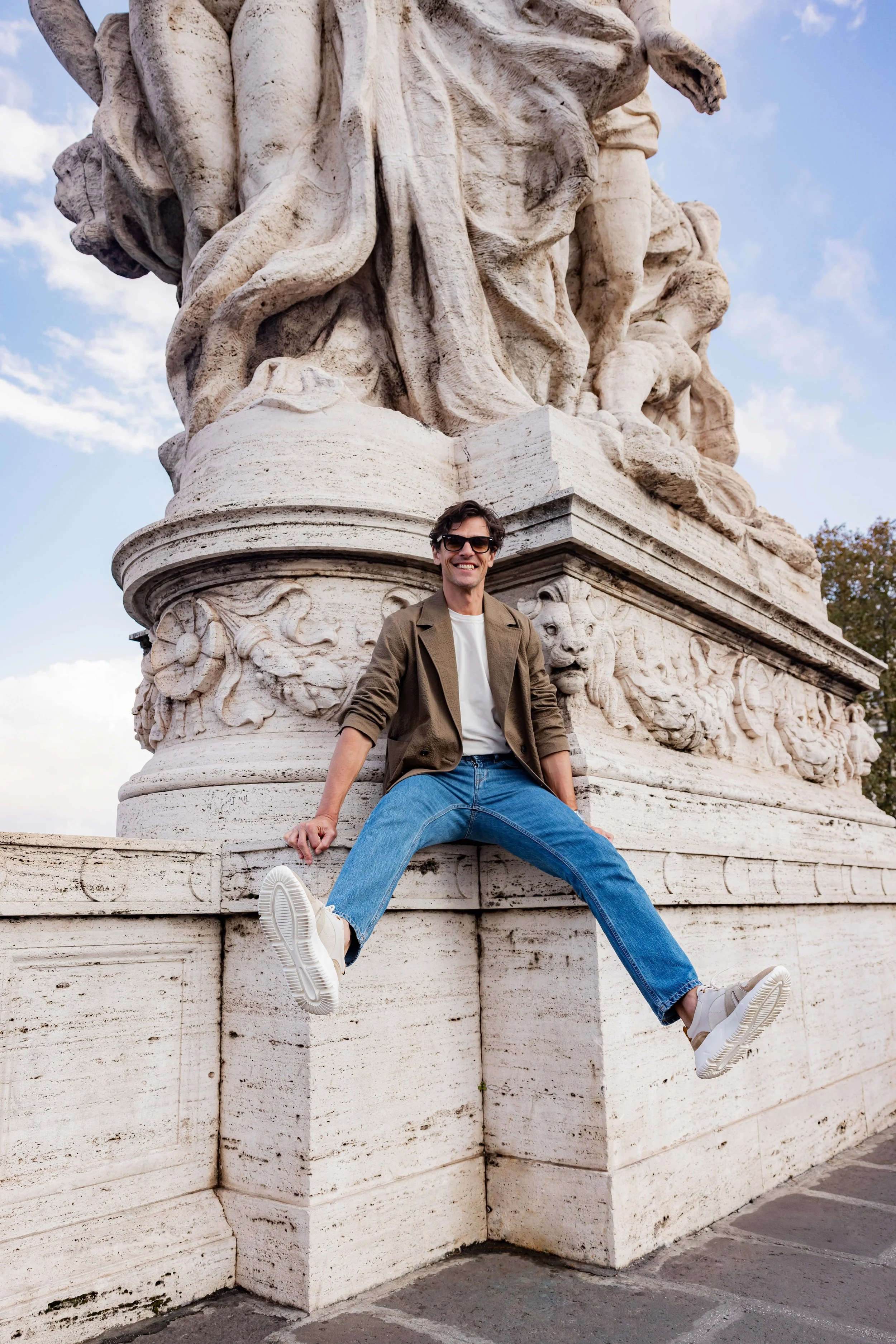 Mannequin homme portant des baskets en cuir assis sur un monument en pierre à Rome