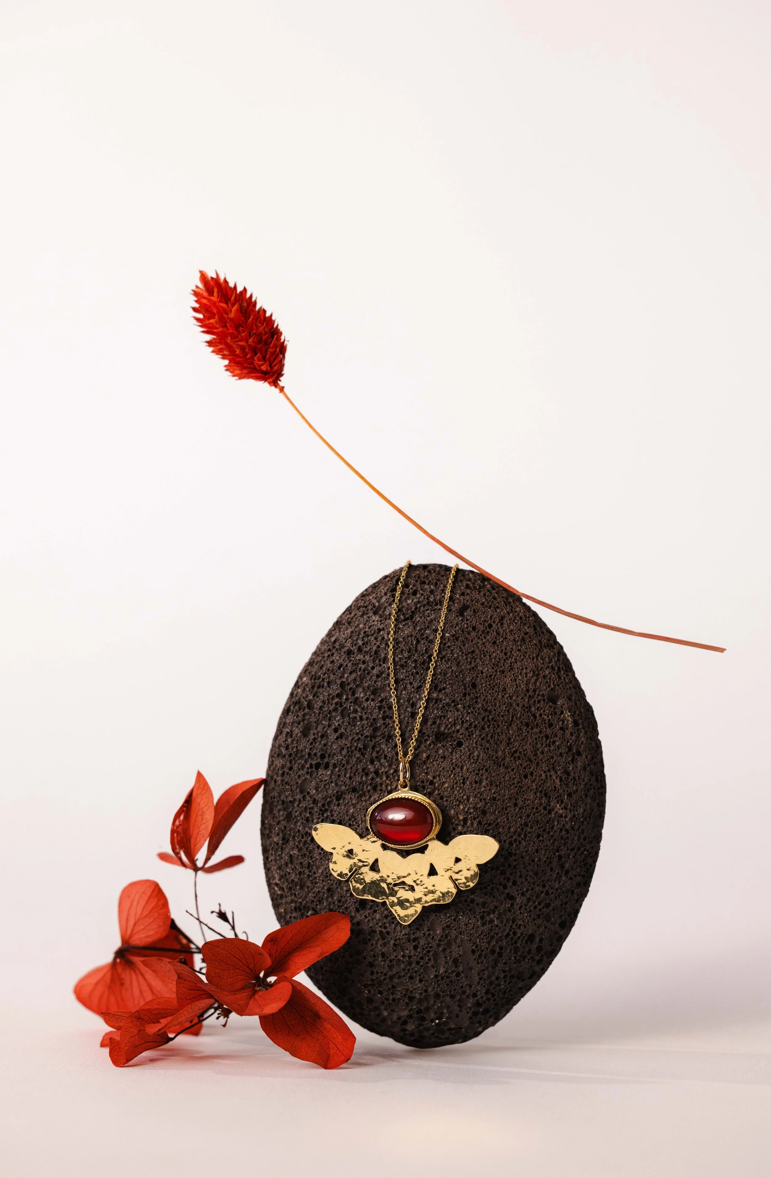 Nature morte d'un collier posé sur une pierre dans une esthétique japonaise