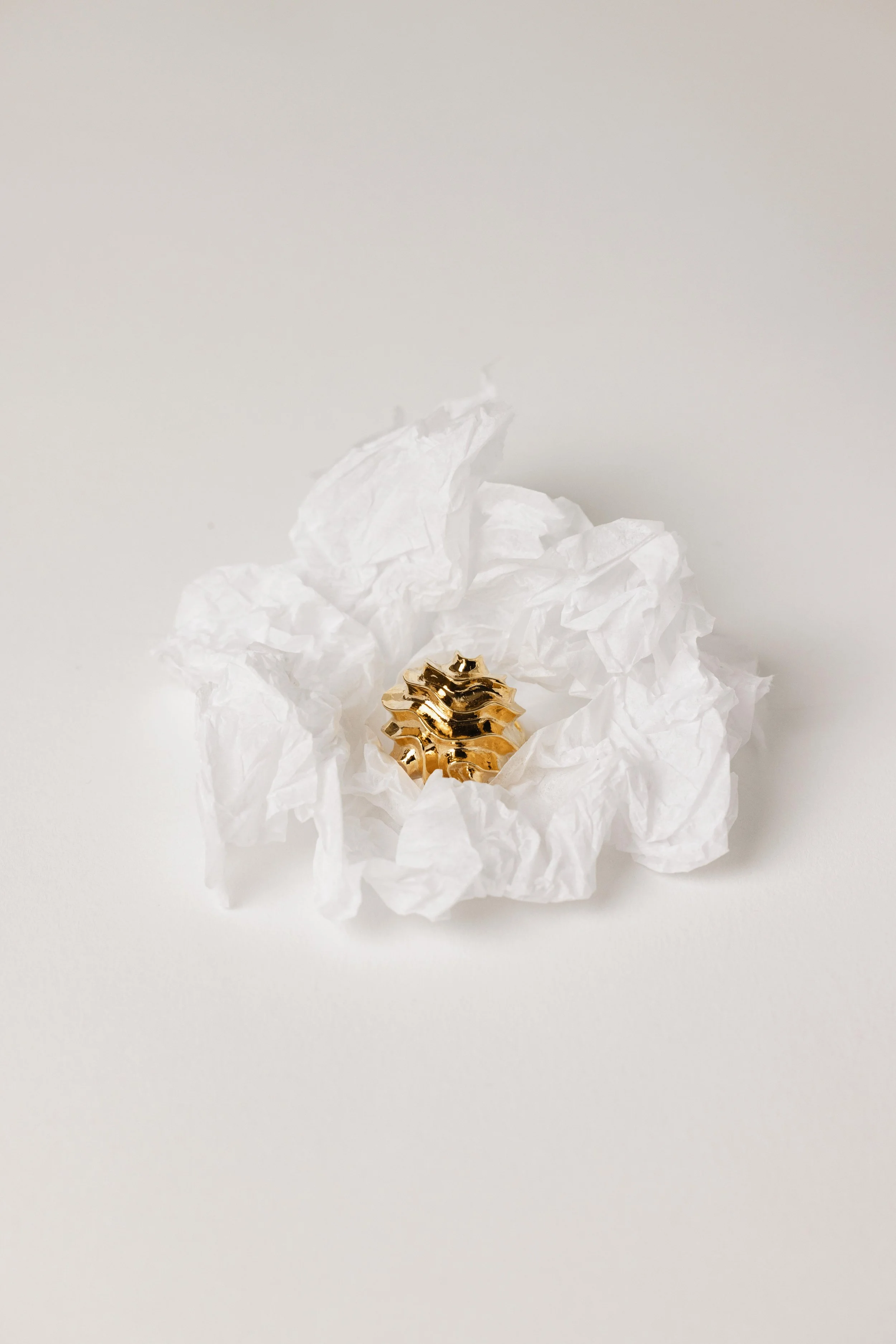 Photo en studio d'une bague en or sur un papier froissé