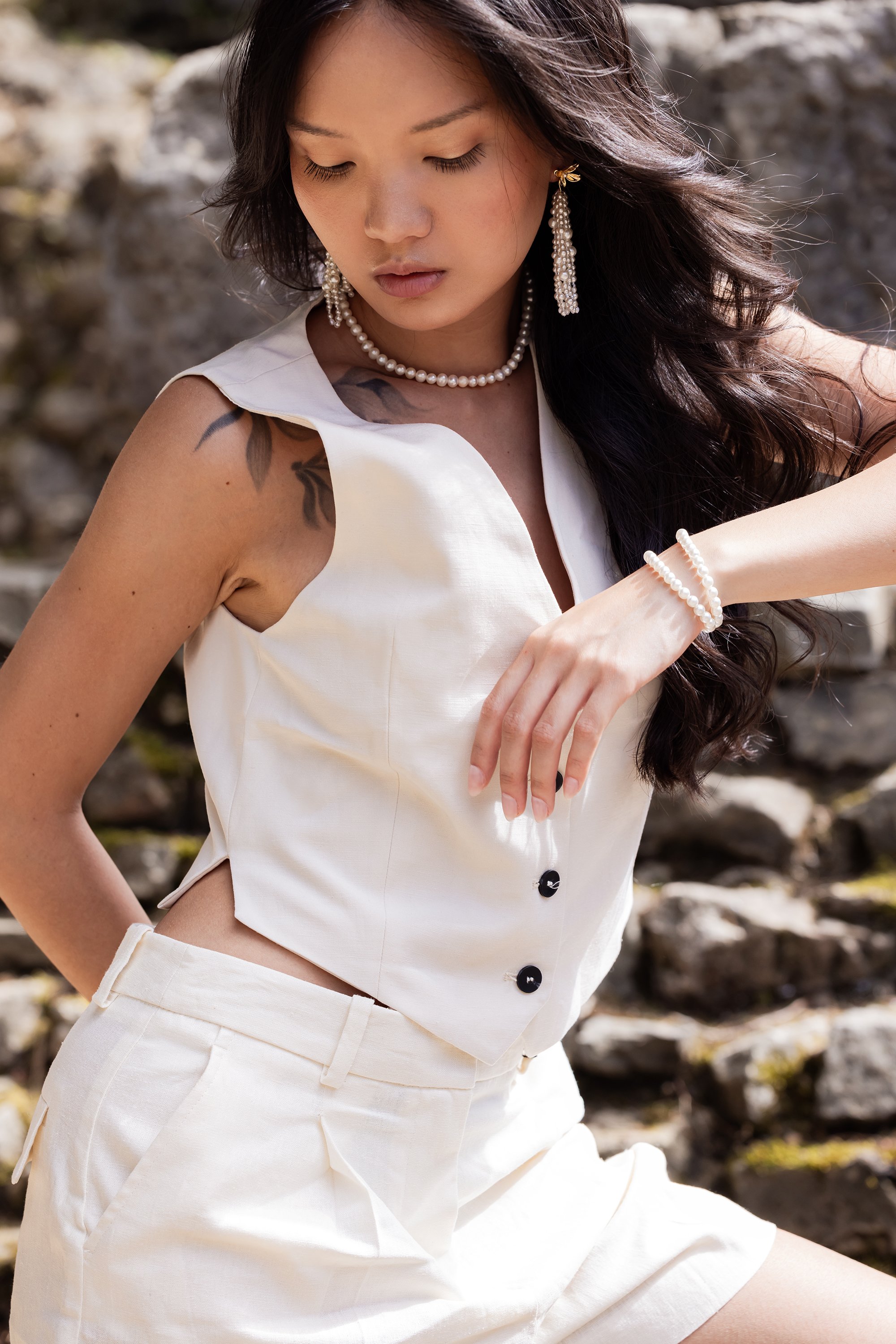 Portrait d'une mannequin en mouvement portant un ensemble en lin et des bijoux en perles