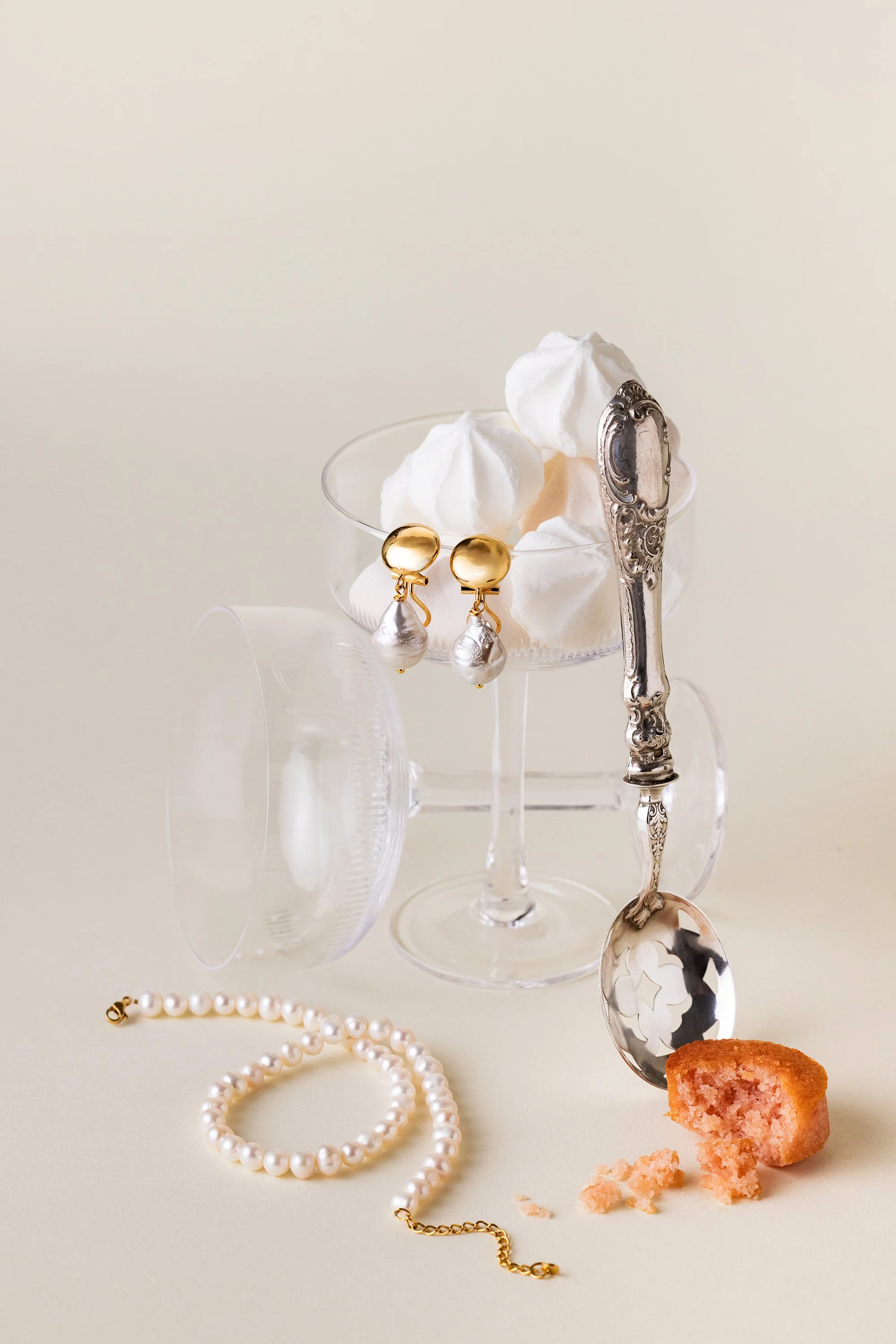 Nature morte de bijoux en perles dans un esprit table de mariage avec verre et cuillère en argent