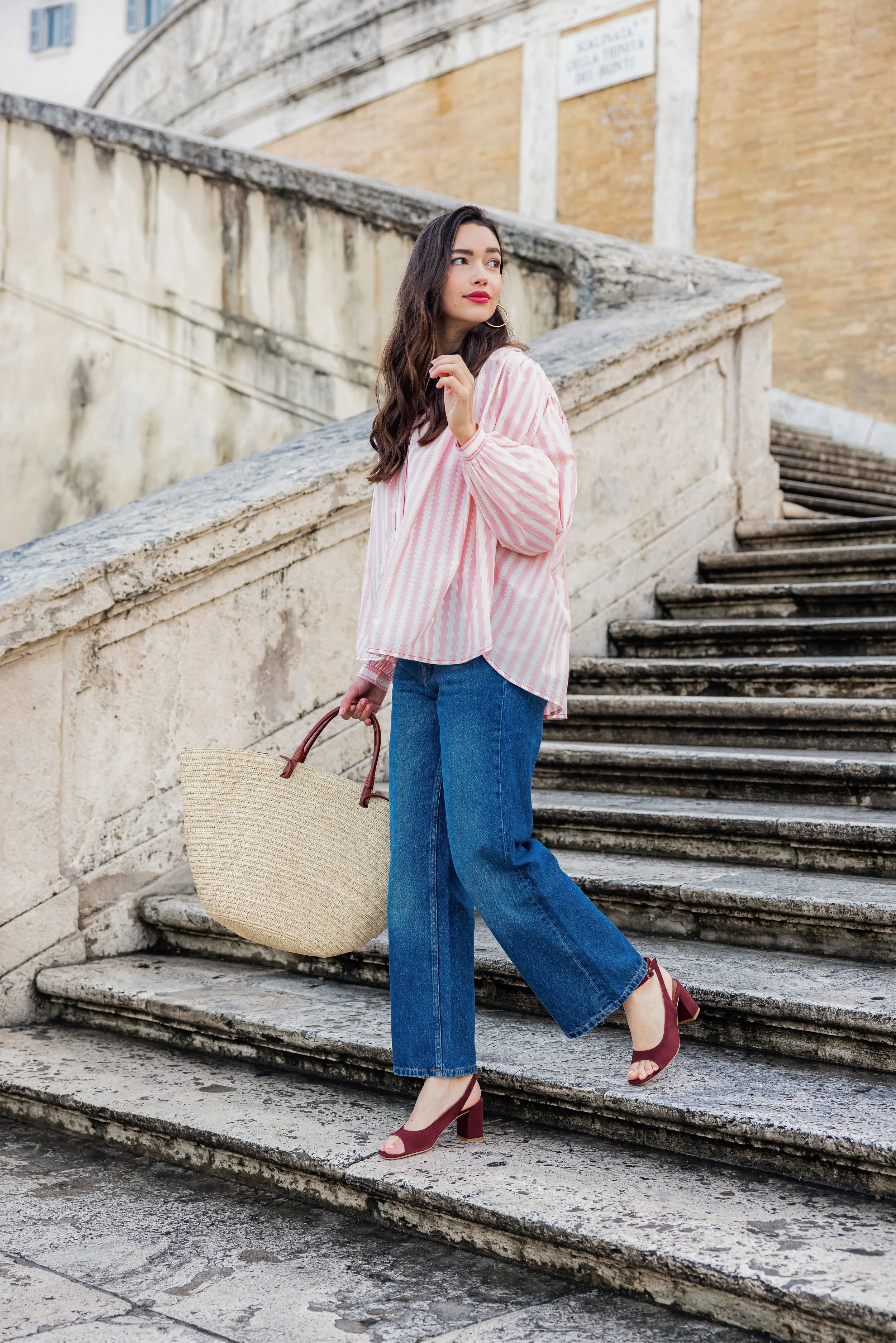Mannequin portant un look urbain et posant dans des escaliers à Rome