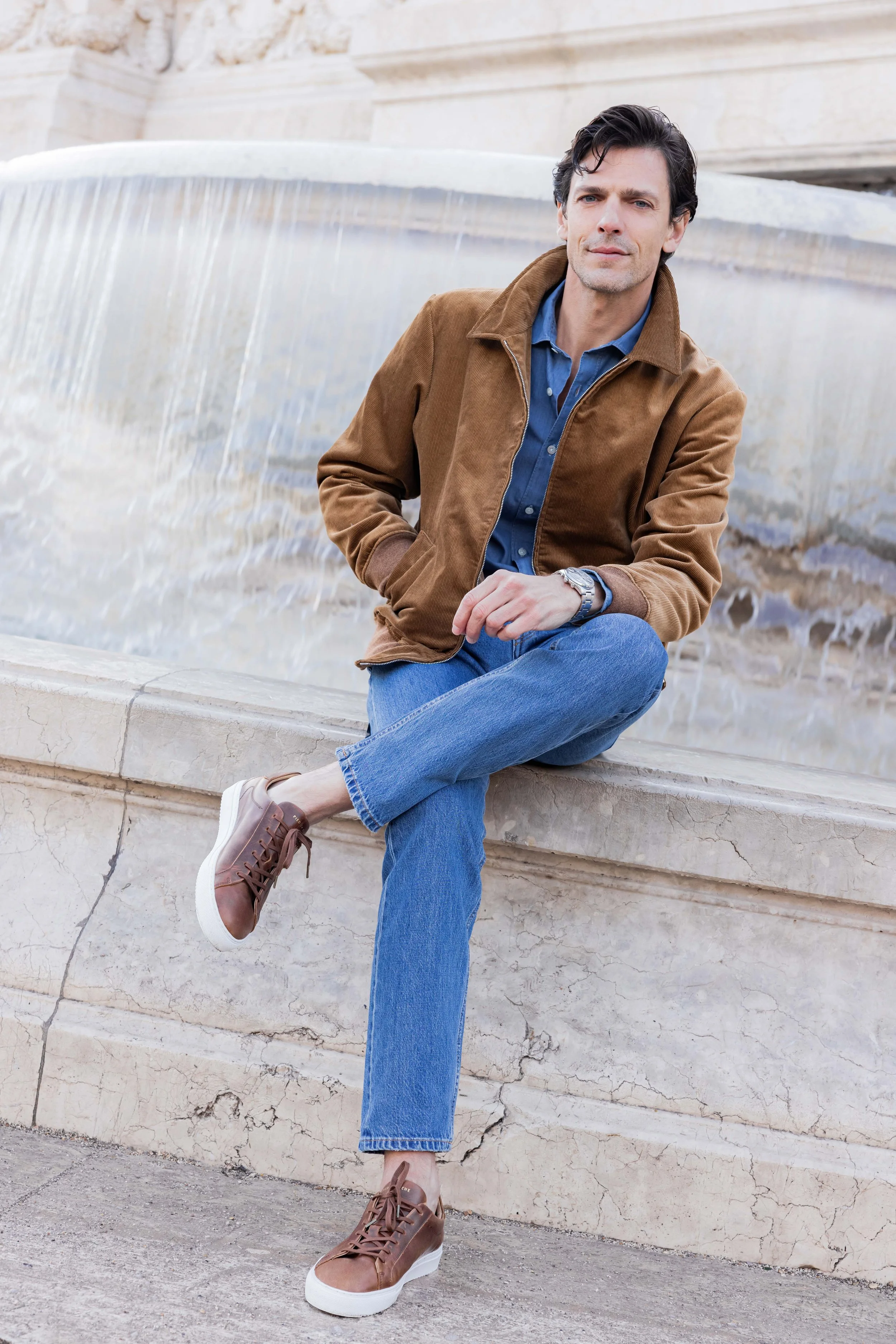Mannequin portant des baskets en cuir et assis sur le rebord d'une fontaine à Rome