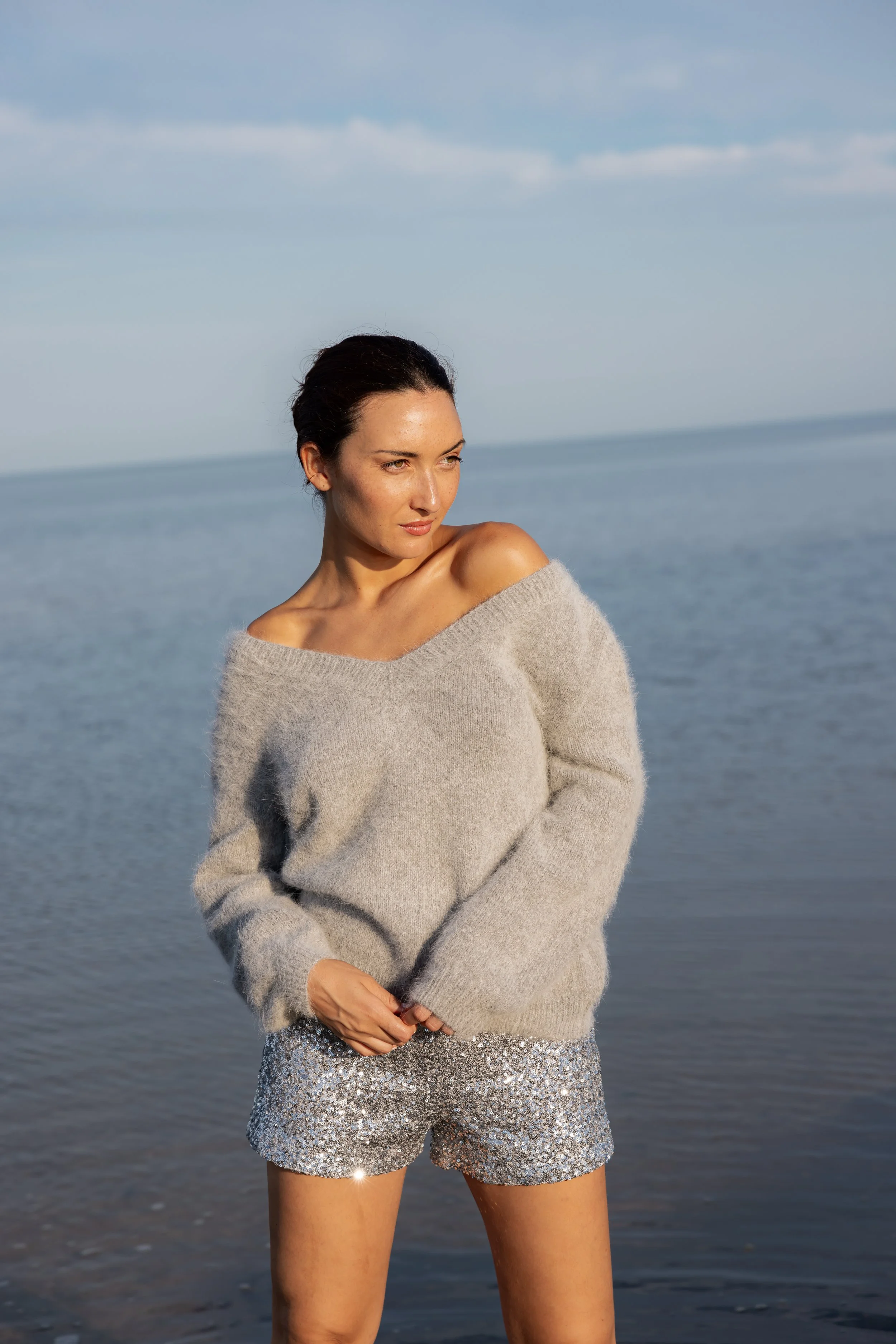 Femme posant debout sous un ciel bleu et posant dans la mer