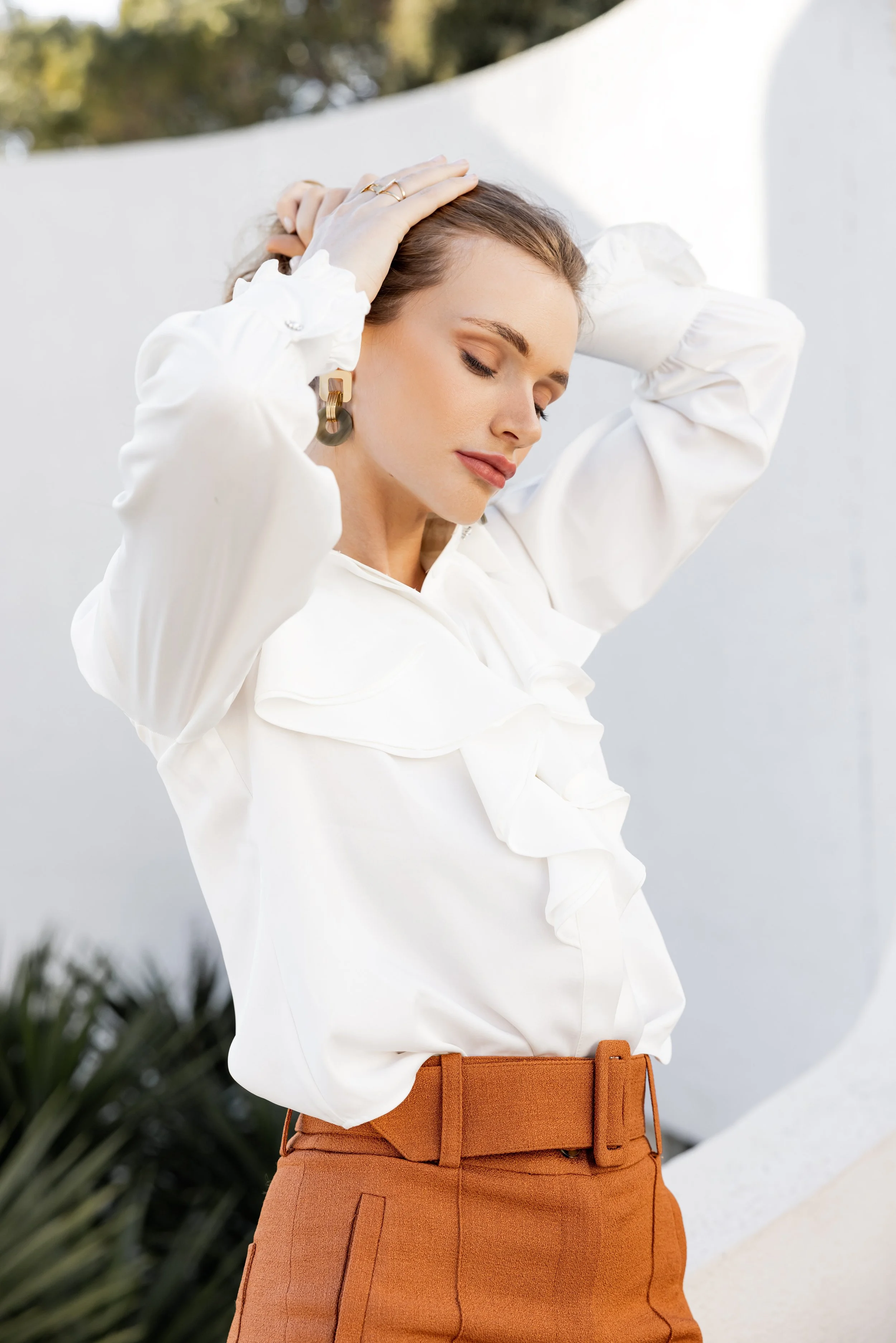 Mannequin tenant ses cheveux en l'air afin de montrer ses boucles d'oreilles