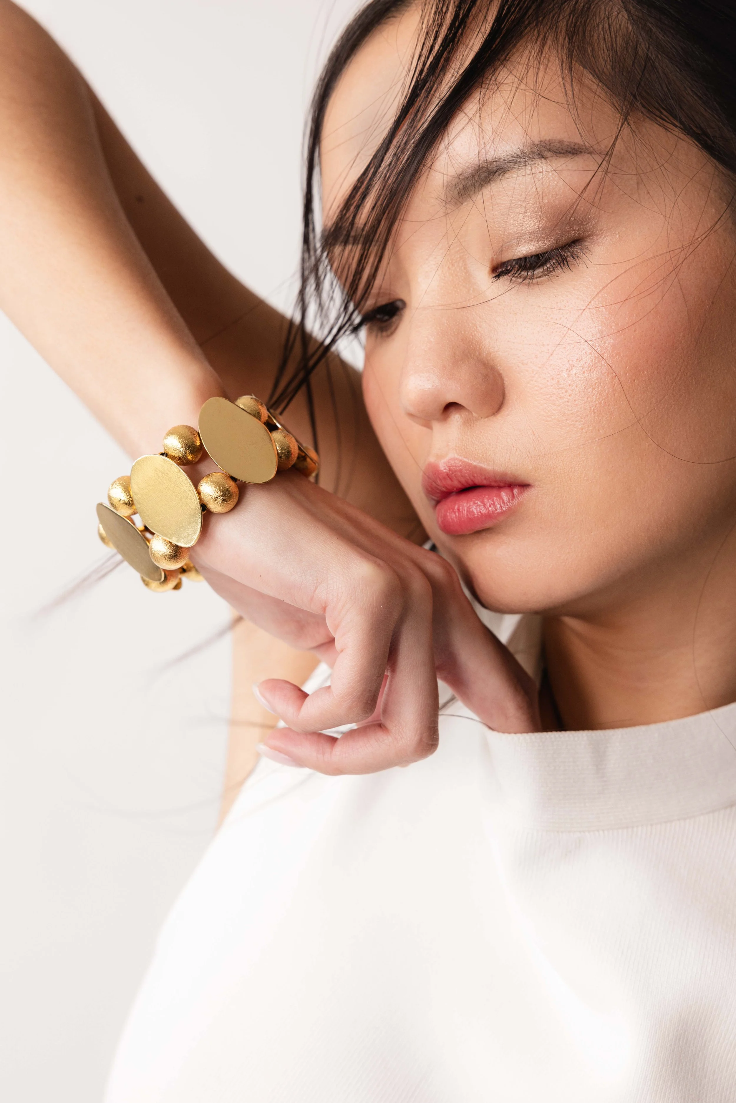 Portrait serré d'une mannequin portant un gros bracelet en or