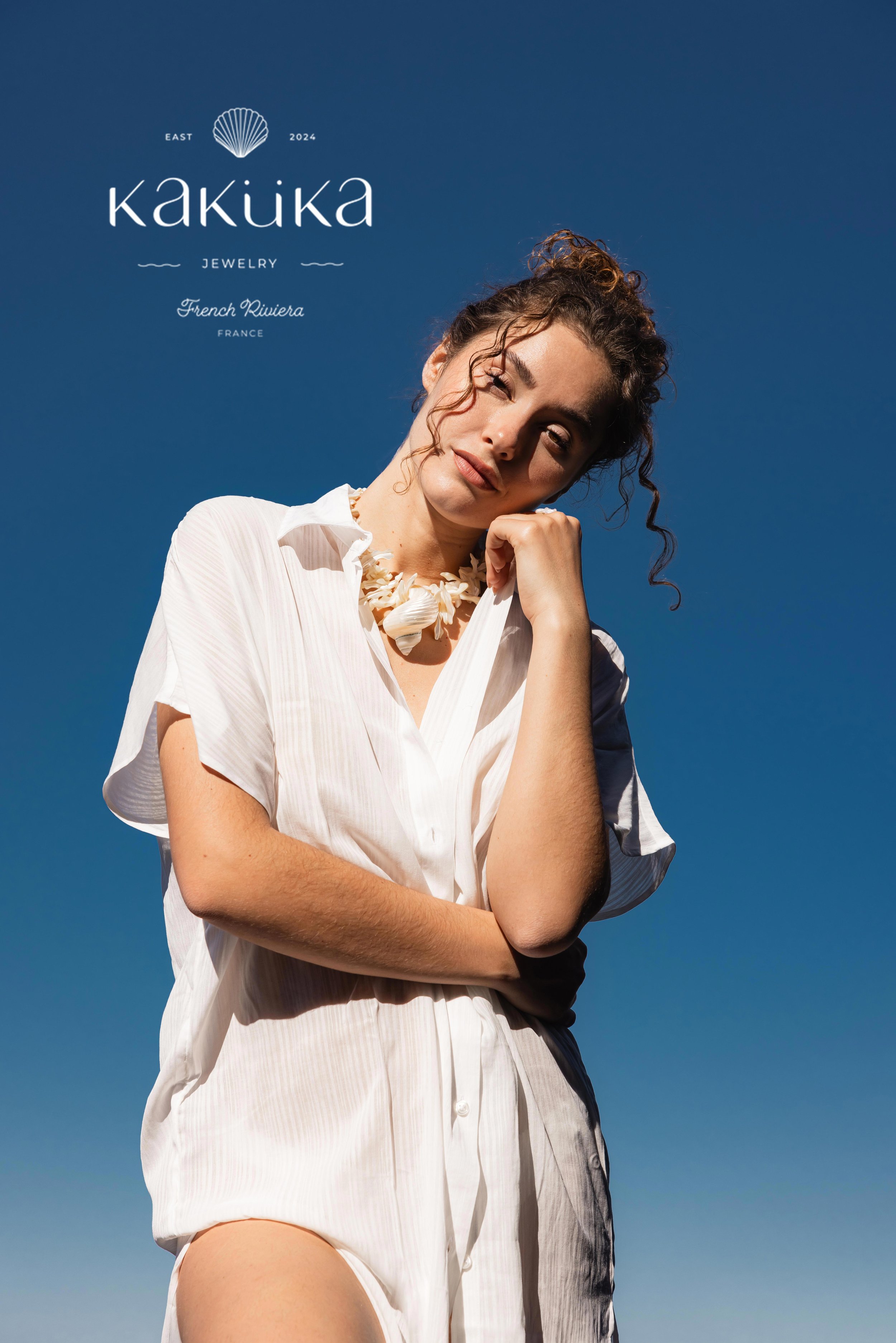 Mannequin portant des bijoux en coquillages sur un fond de ciel bleu
