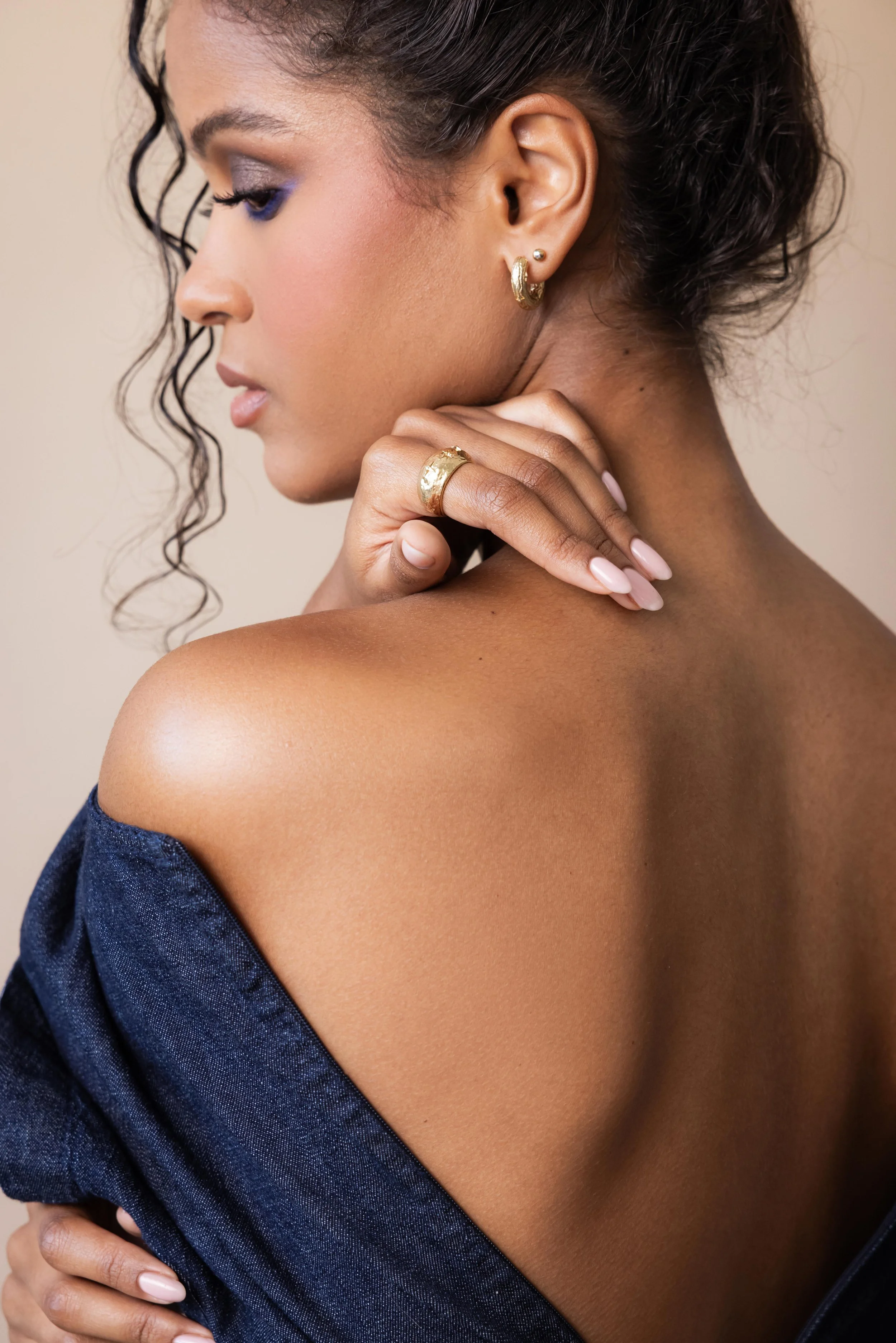 Mannequin de dos portant une robe en jean et des bijoux en or