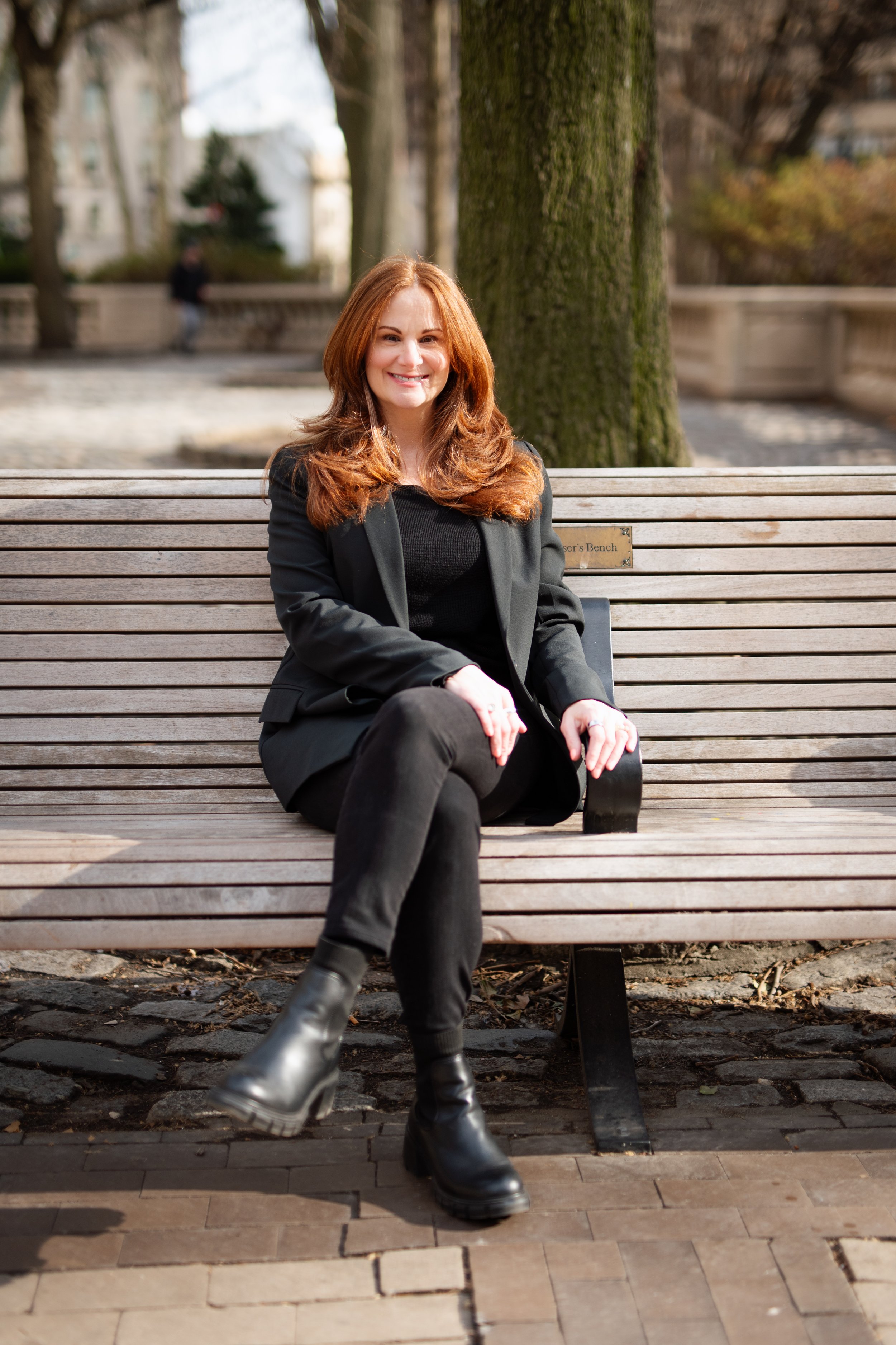 Andrea Bernstein sitting on a park bench in a peaceful urban setting