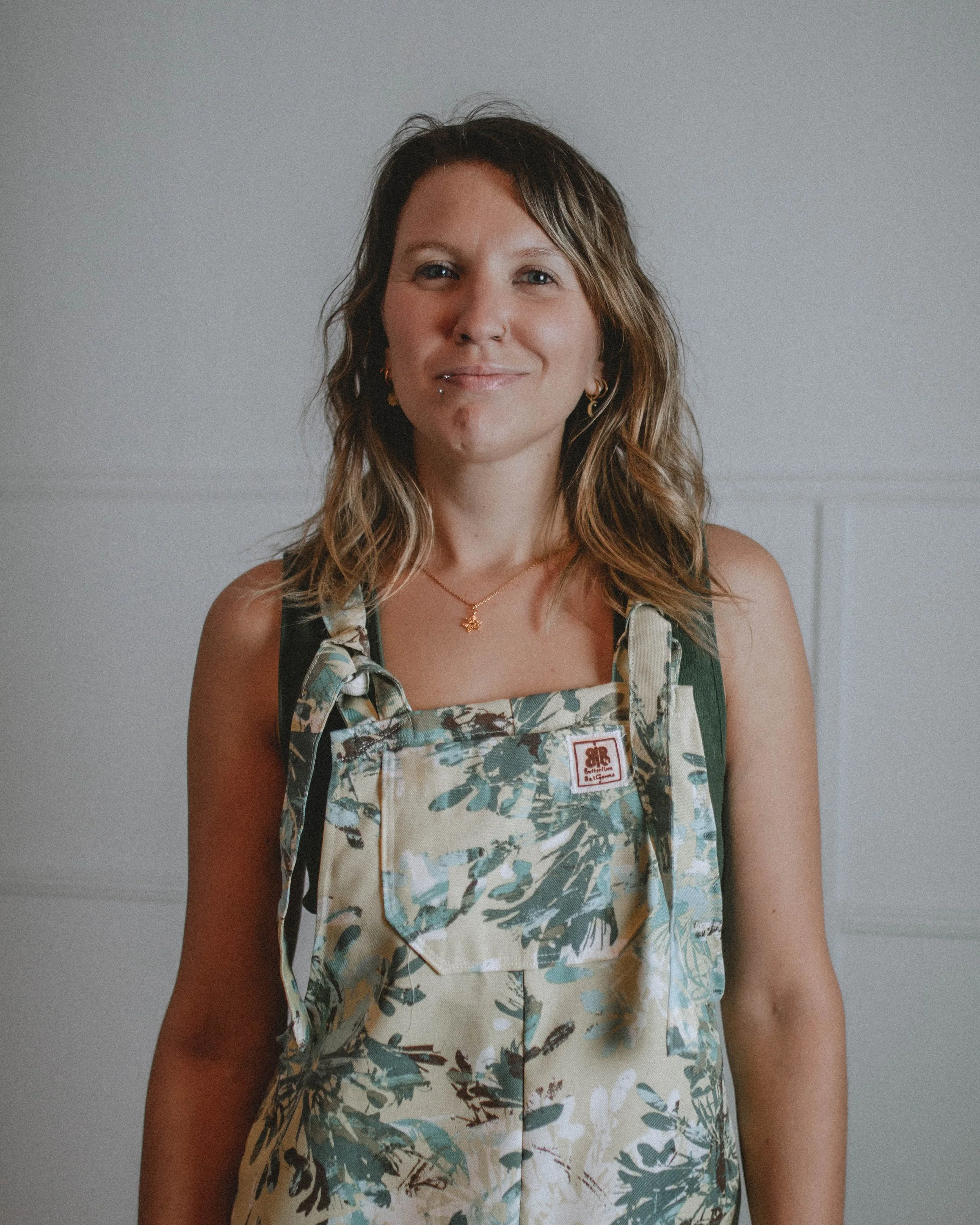 a woman wear the Butterflies in Ballgowns teal dreamscape dungarees that are one of a kind and sustainably made in Nelson BC
