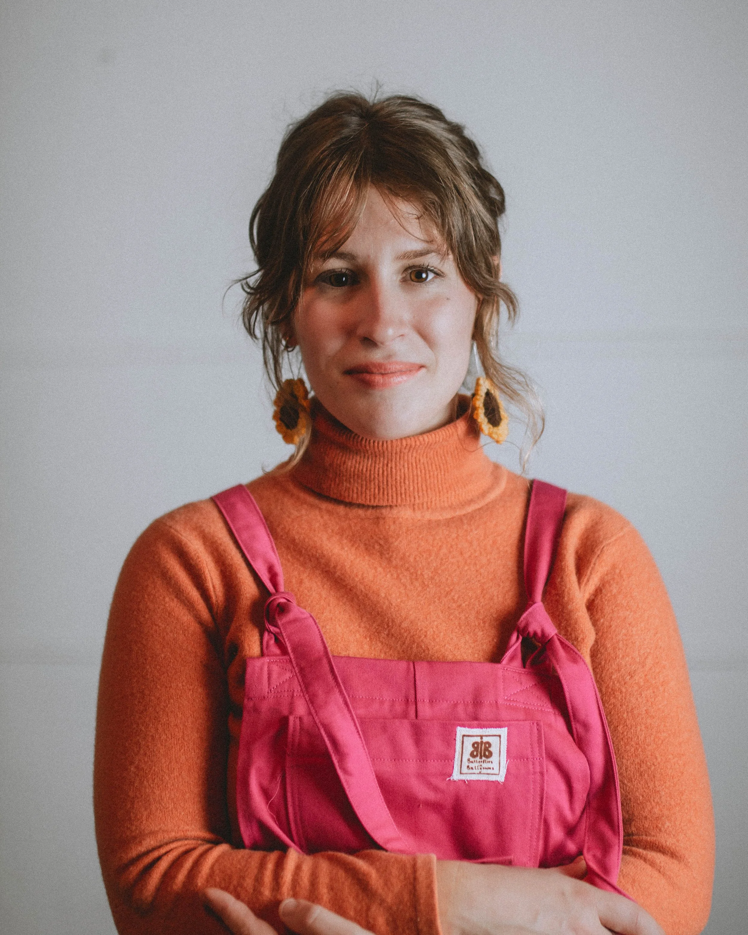 Vibrant pink upcycled overalls, a perfect example of dopamine dressing for sustainable fashion lovers. Handcrafted yellow sunflower earrings for dopamine dressing by Butterflies in Ballgowns, Nelson BC.