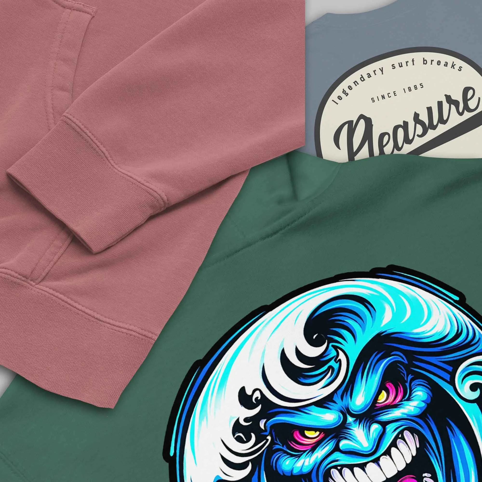 Close-up collage of SCSTZ apparel featuring a pink hoodie sleeve, a green hoodie with a bold blue wave face graphic, and a blue shirt with a Pleasure Point surf logo.