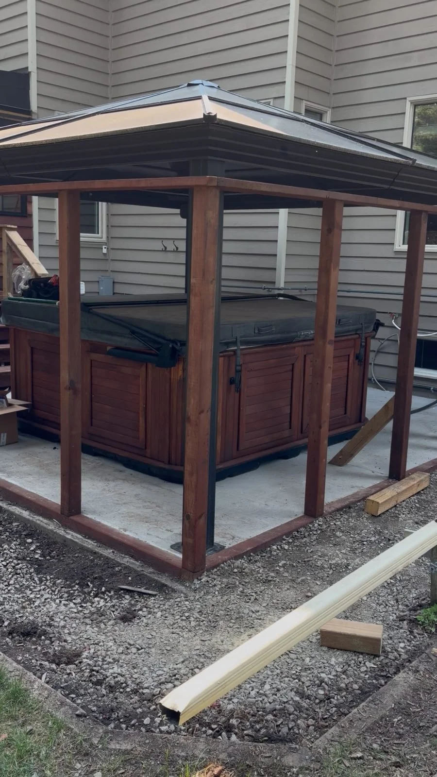 Hot tub under a cedar gazebo on a concrete patio in Redwood Meadows, wired by Koop Electrical