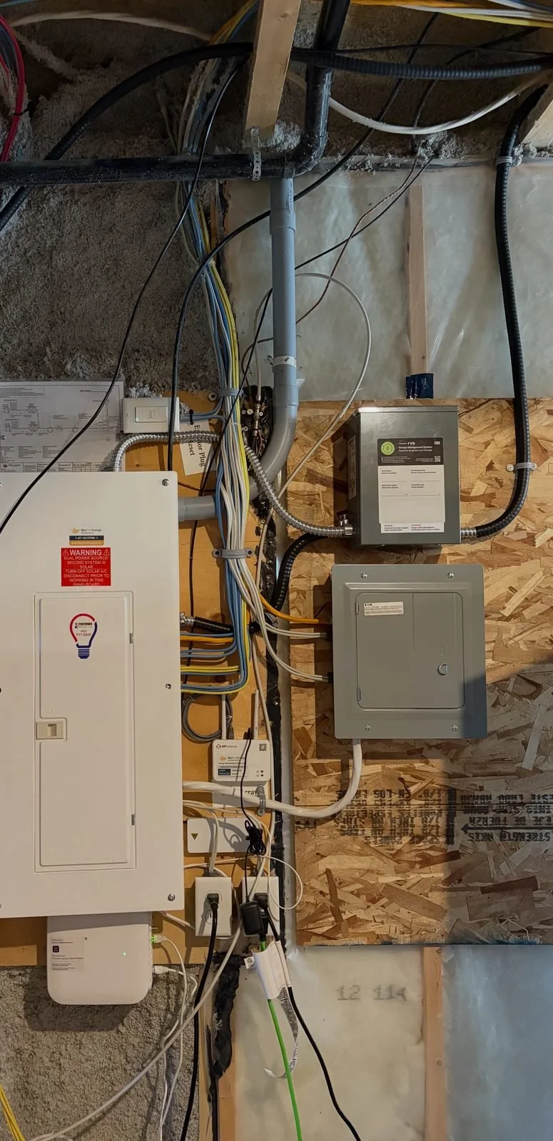 EV energy management system controller installed by Koop Electrical beside the main electrical panel in a Mahogany, Calgary basement