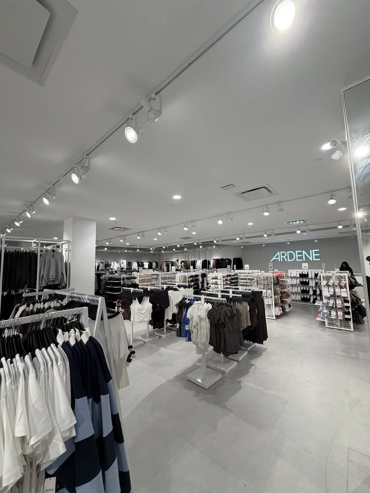 Track lighting runs across the Ardene sales floor toward the cash desk, showing the mix of older and newer heads