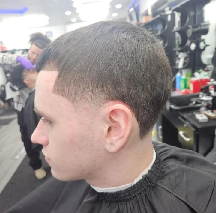 Side profile of a men's short Caesar-style cut with a low taper and clean edges, cut by Ben Santiago at Gem City Barbers in Erie, PA.