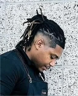 Side profile of a men's loc hairstyle with a sharp line-up and tapered fade on the sides, styled at Gem City Barbers in Erie, PA.