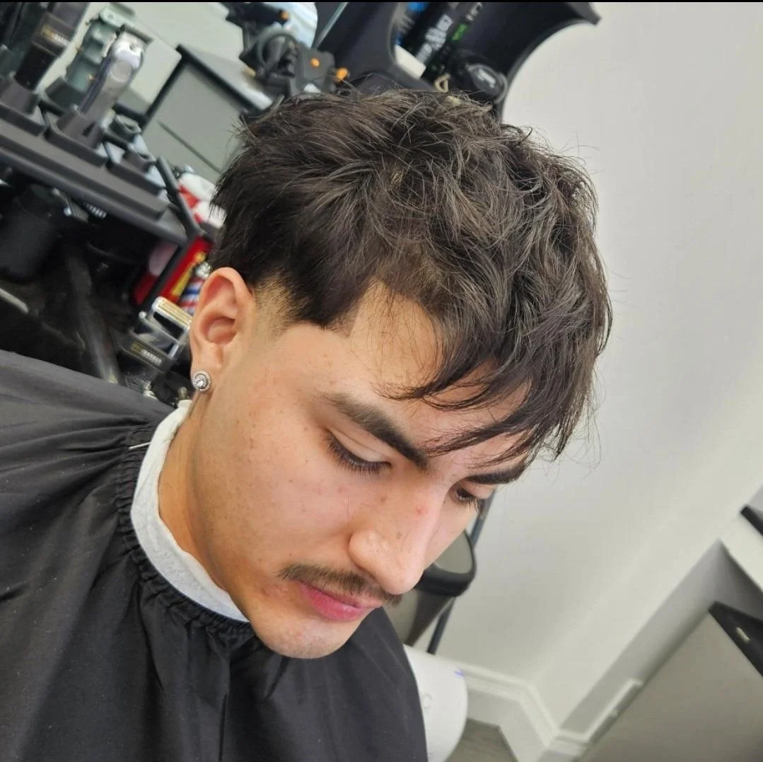 Front view of a men's textured messy fringe haircut with natural movement on top, cut by Ben Santiago at Gem City Barbers in Erie, PA.
