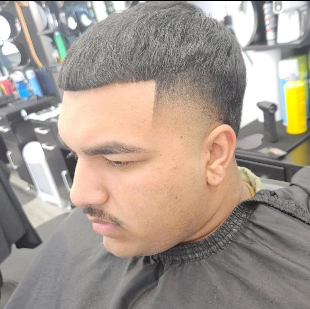 Front view of a men's short crop with a blunt fringe line and low skin fade, cut by Ben Santiago at Gem City Barbers in Erie, PA.