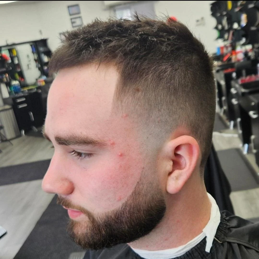 Side view of a men's short textured crop with a mid fade and trimmed beard, cut by Ben Santiago at Gem City Barbers in Erie, PA.
