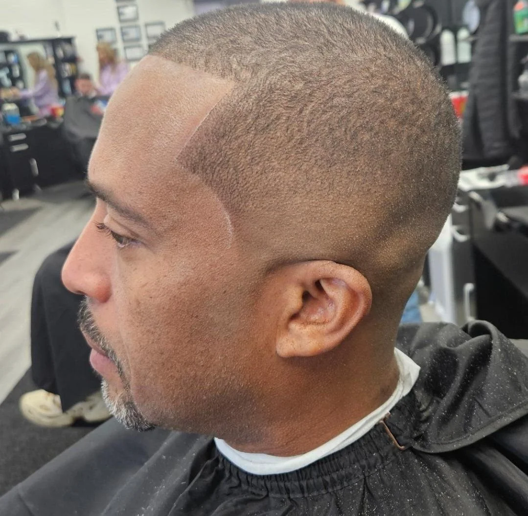 Side profile of a men's skin fade buzz cut with a precise line-up, styled at Gem City Barbers in Erie, PA.