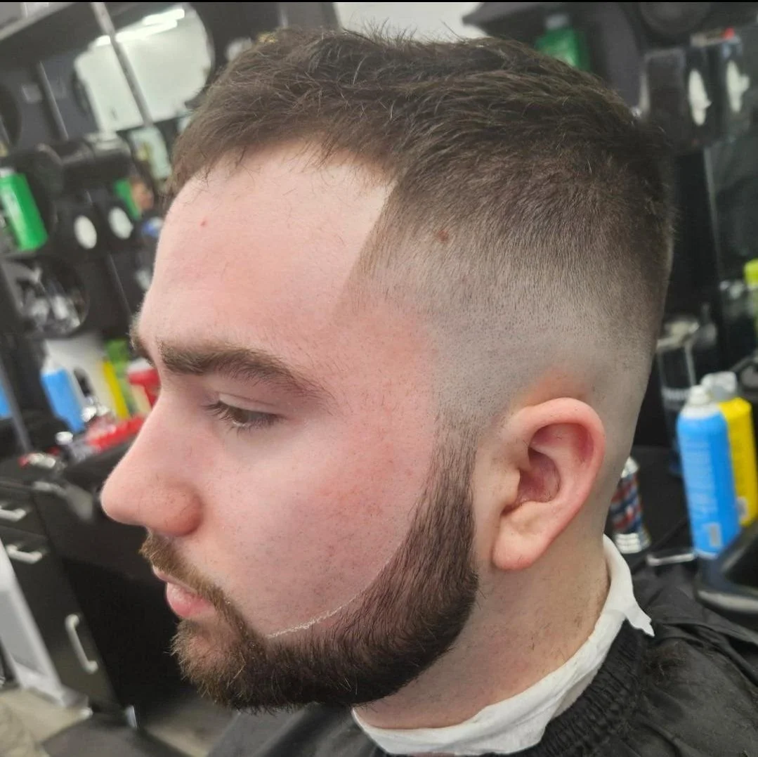 Side view of a men's high and tight buzz cut with a sharp line-up and trimmed beard, done at Gem City Barbers in Erie, PA.