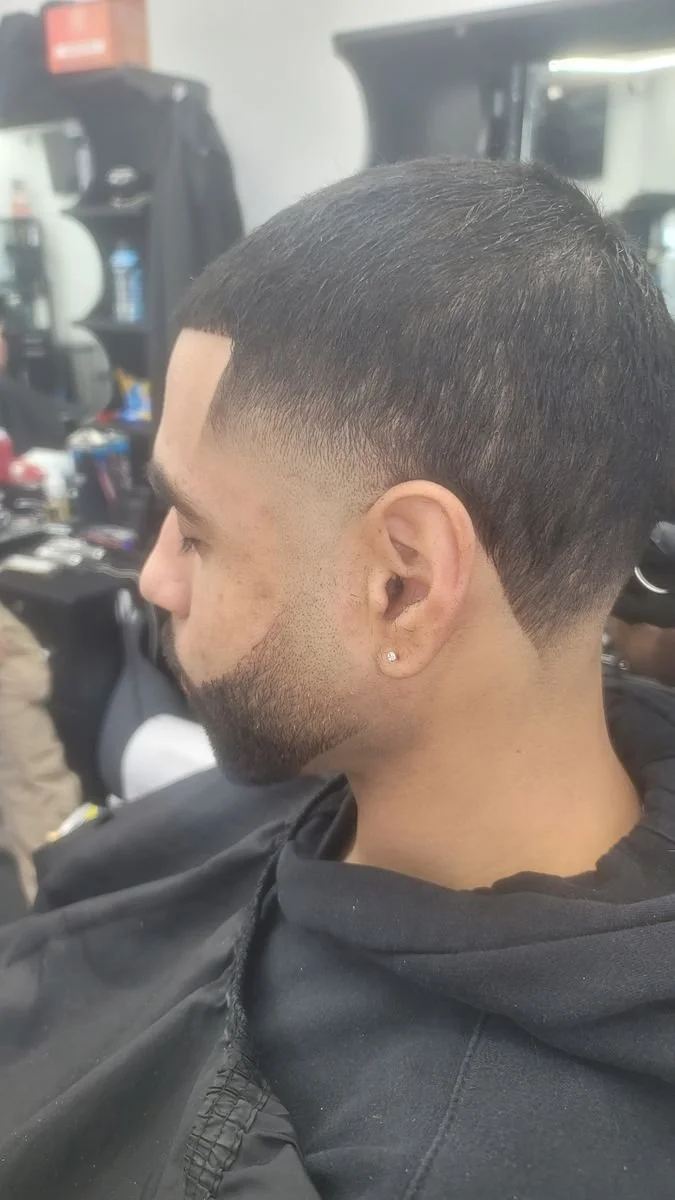 Side and back view of a men's clean low taper haircut with a lined-up beard, completed at Gem City Barbers in Erie, PA.