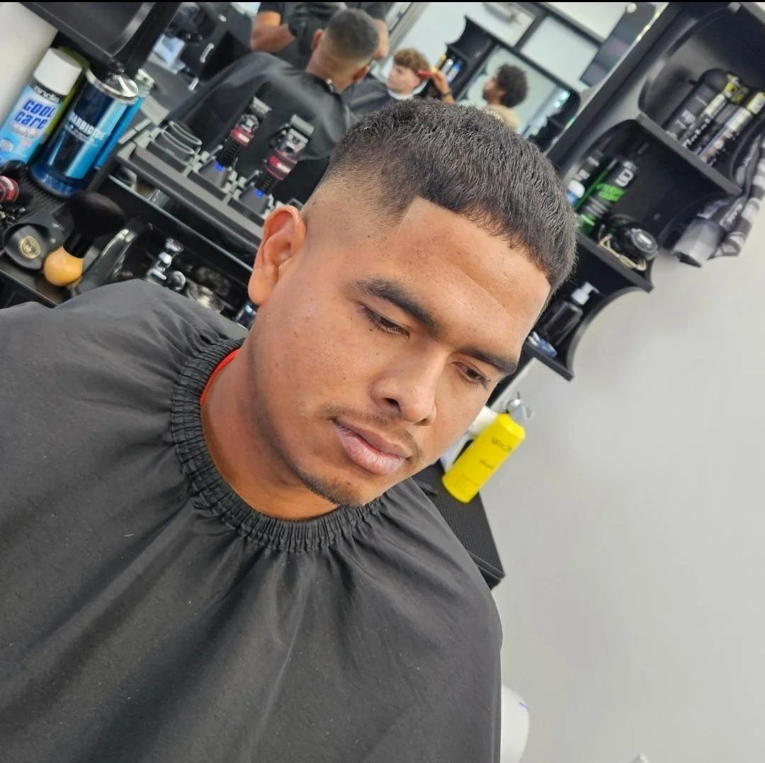 Front view of a men's short buzz with a low fade and natural hairline, completed at Gem City Barbers in Erie, PA.