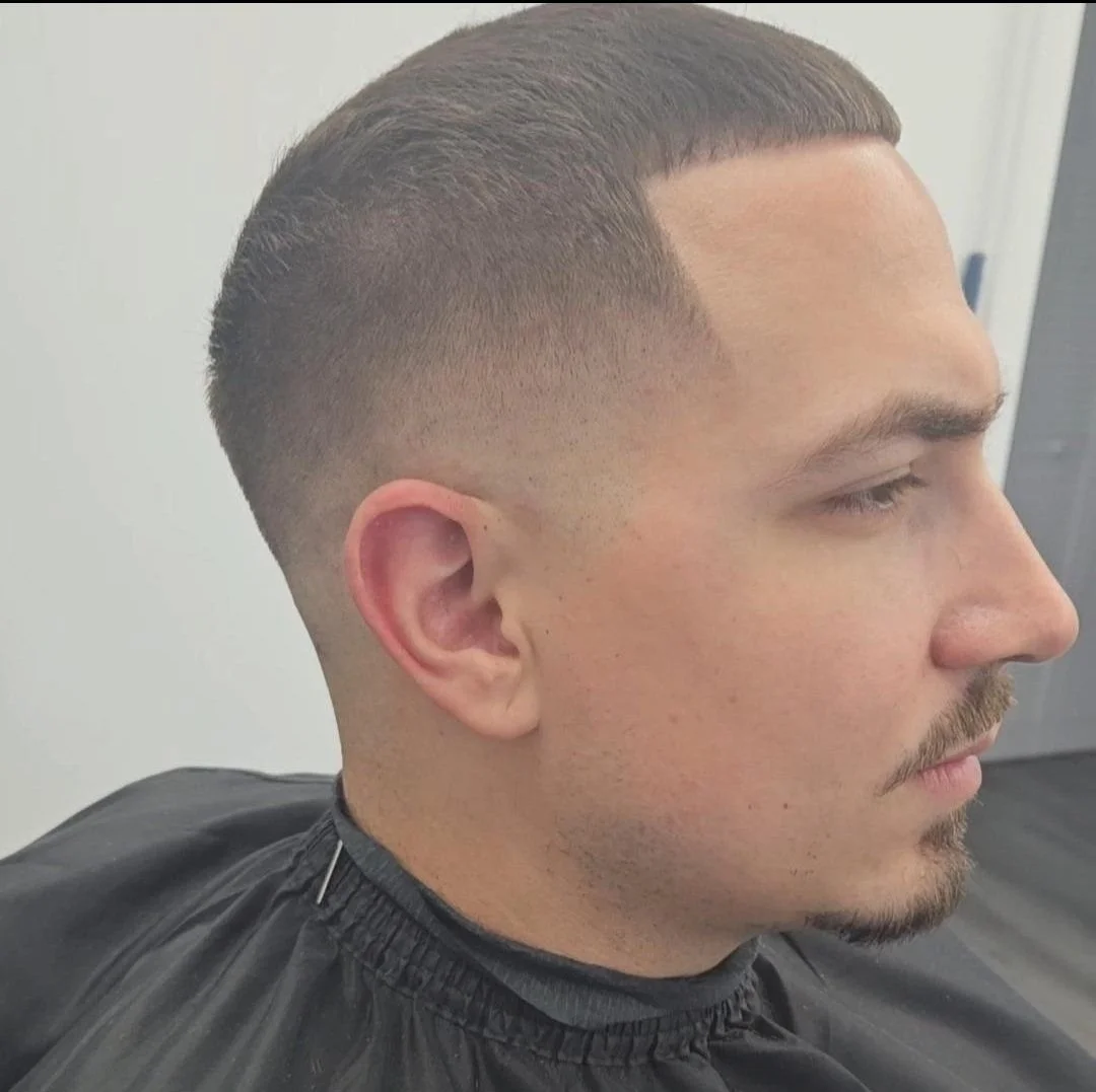 Side profile of a men's high and tight fade with a sharp line-up and clean edges, styled at Gem City Barbers in Erie, PA.